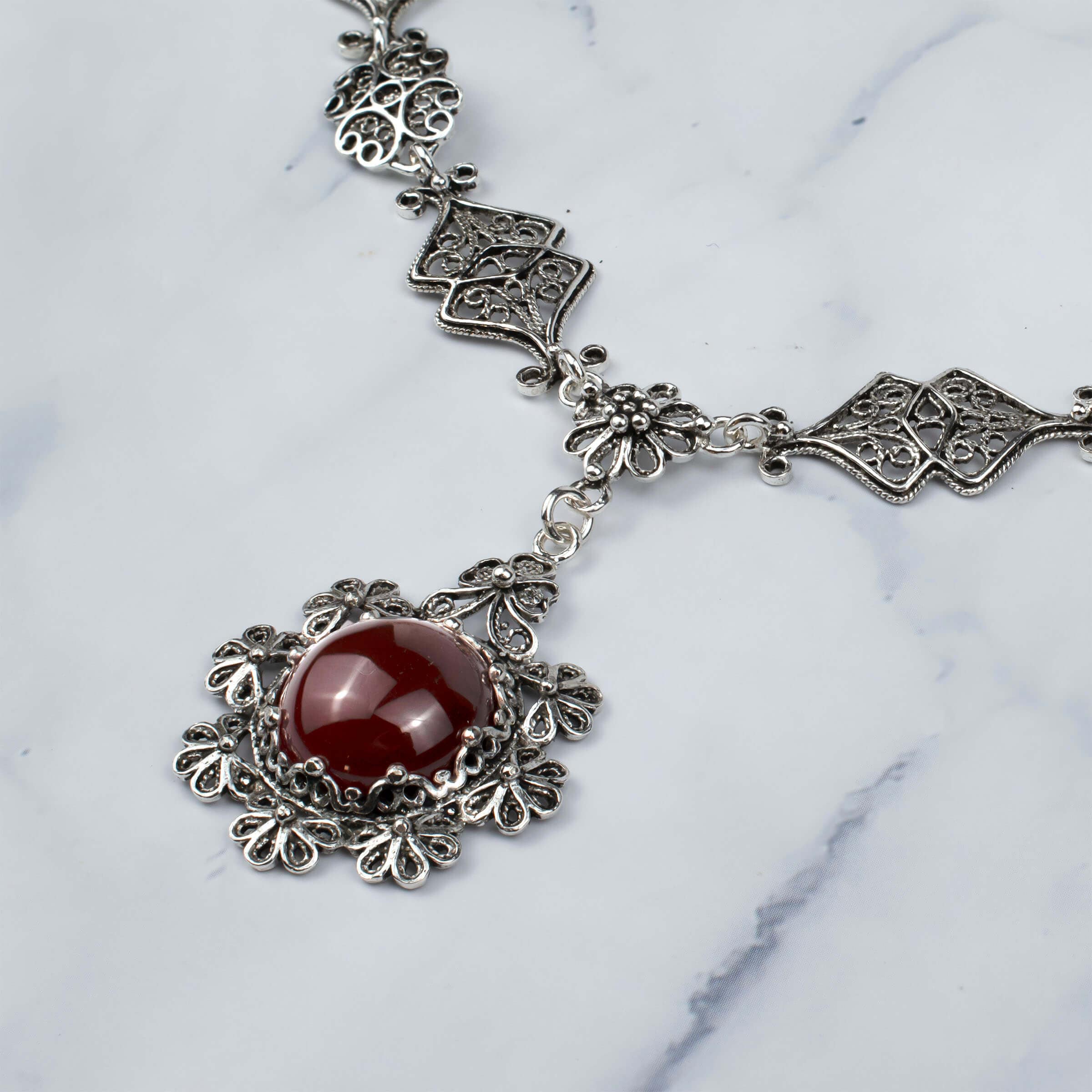 Elegant silver choker necklace featuring a round Carnelian gemstone centerpiece with intricate filigree design.