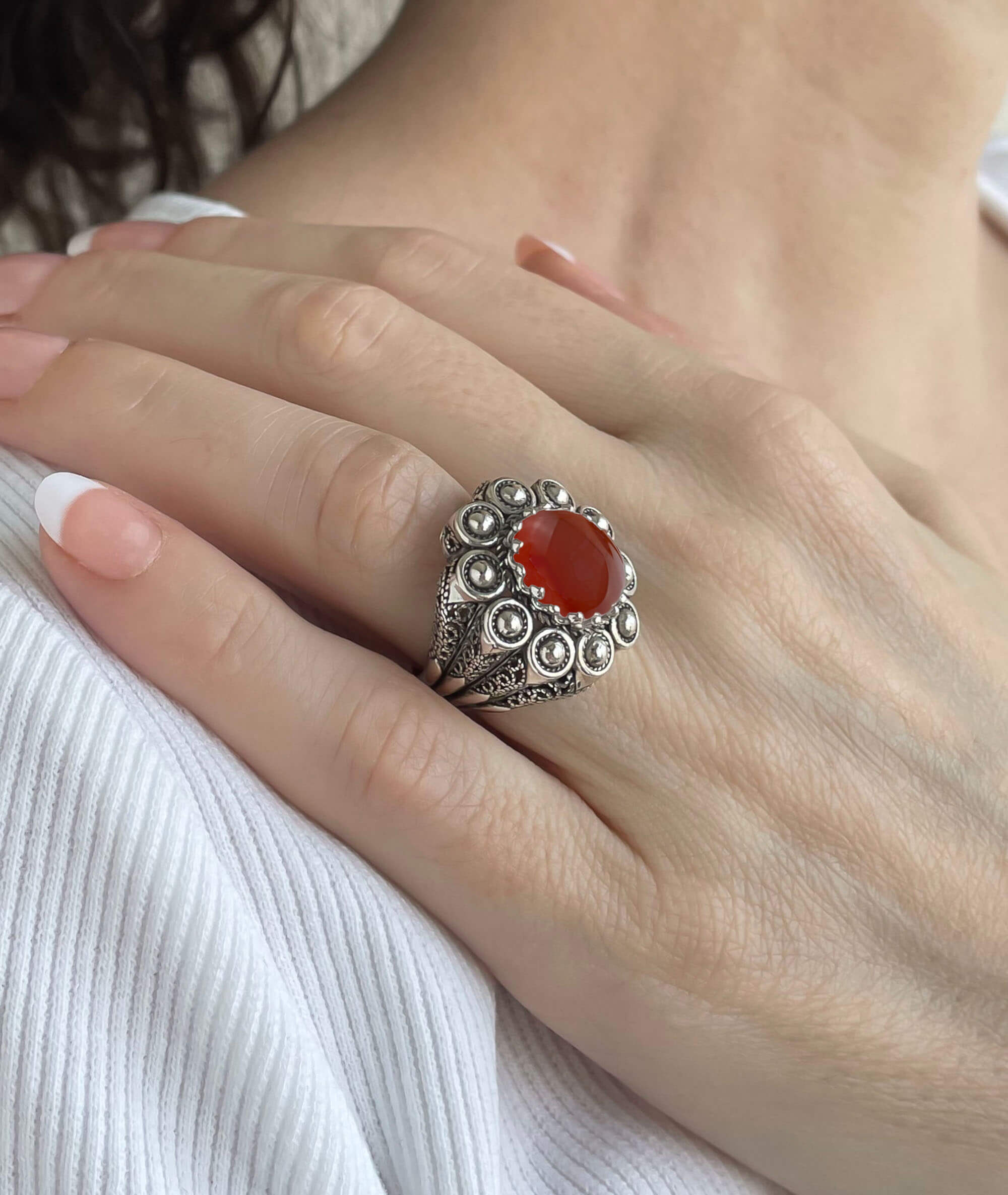 A handcrafted filigree art dome ring featuring a vibrant Carnelian gemstone set in oxidized 925 sterling silver, elegantly displayed in a gift box.