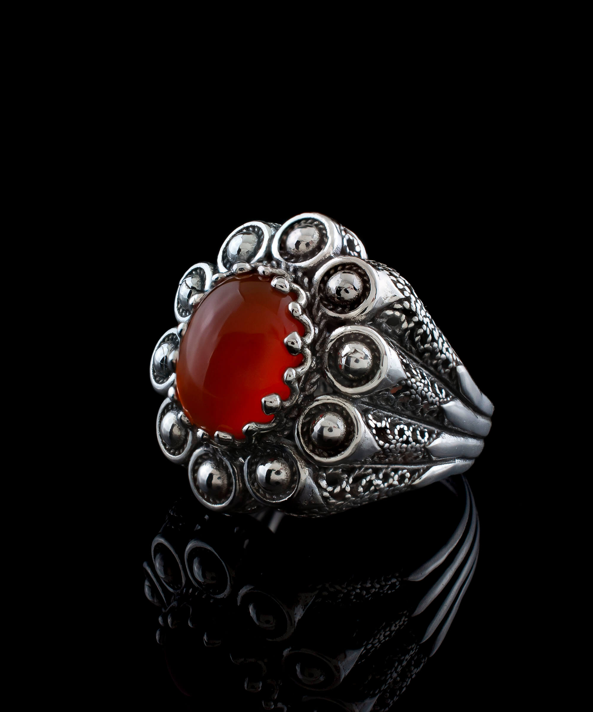 A handcrafted filigree art dome ring featuring a vibrant Carnelian gemstone set in oxidized 925 sterling silver, elegantly displayed in a gift box.