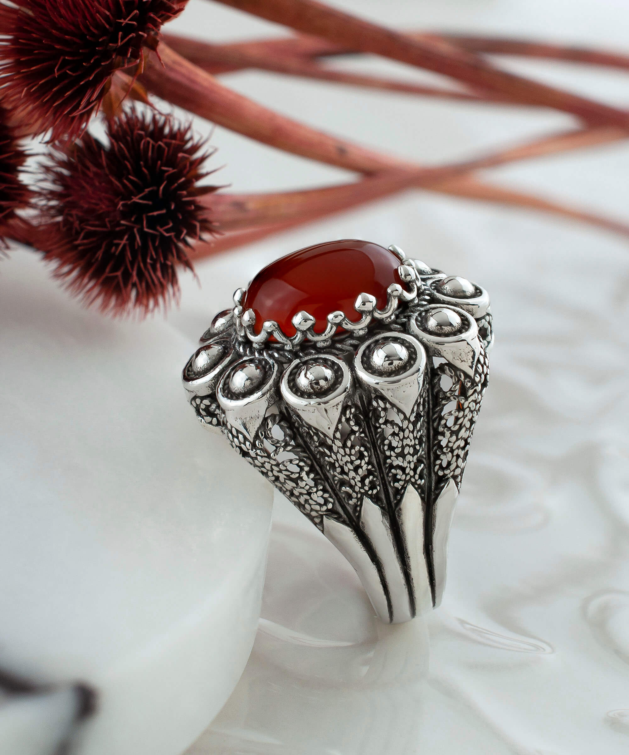 A handcrafted filigree art dome ring featuring a vibrant Carnelian gemstone set in oxidized 925 sterling silver, elegantly displayed in a gift box.