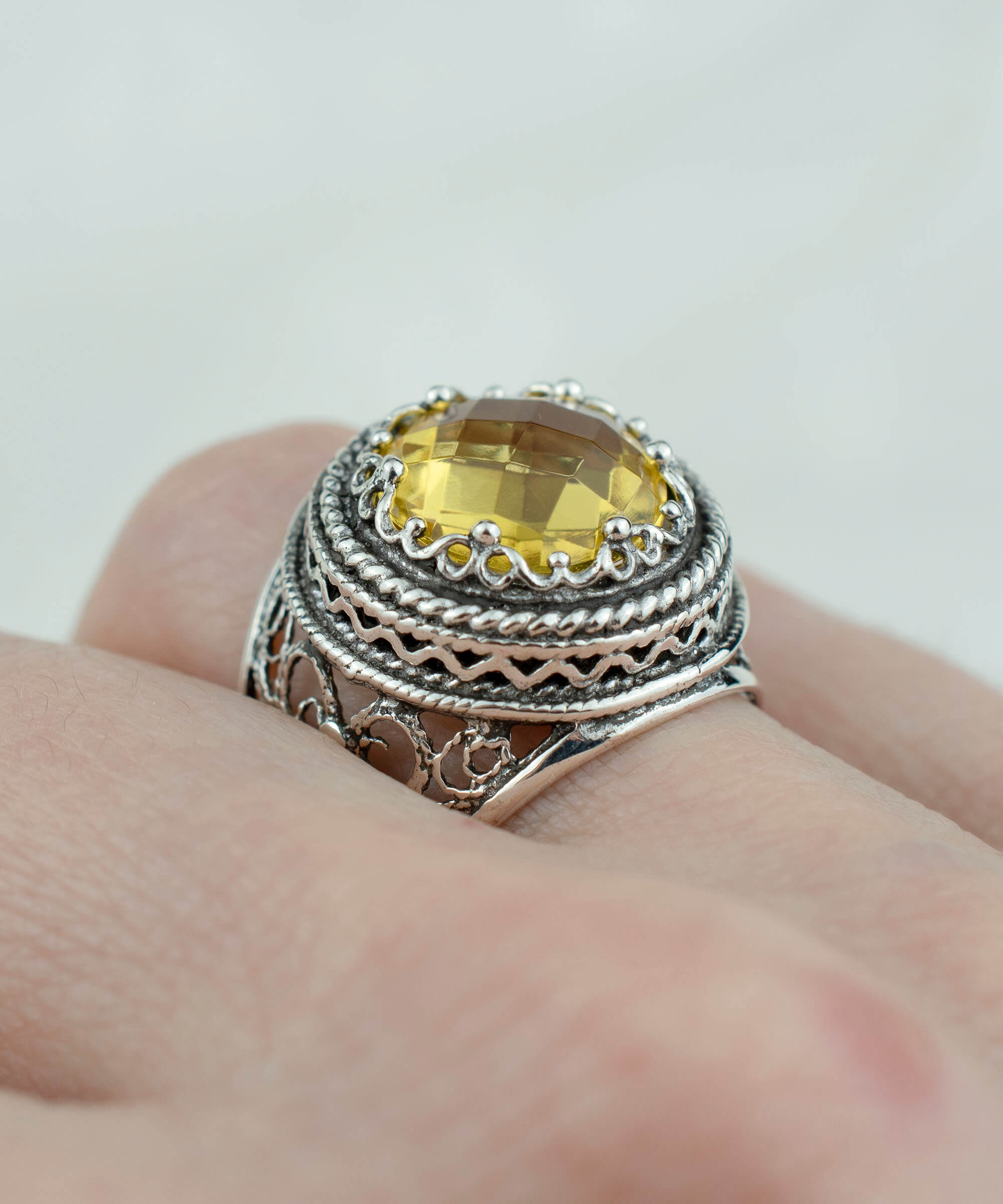 A stunning sterling silver bold ring featuring a 12mm double-sided faceted citrine gemstone, showcasing intricate filigree art design.