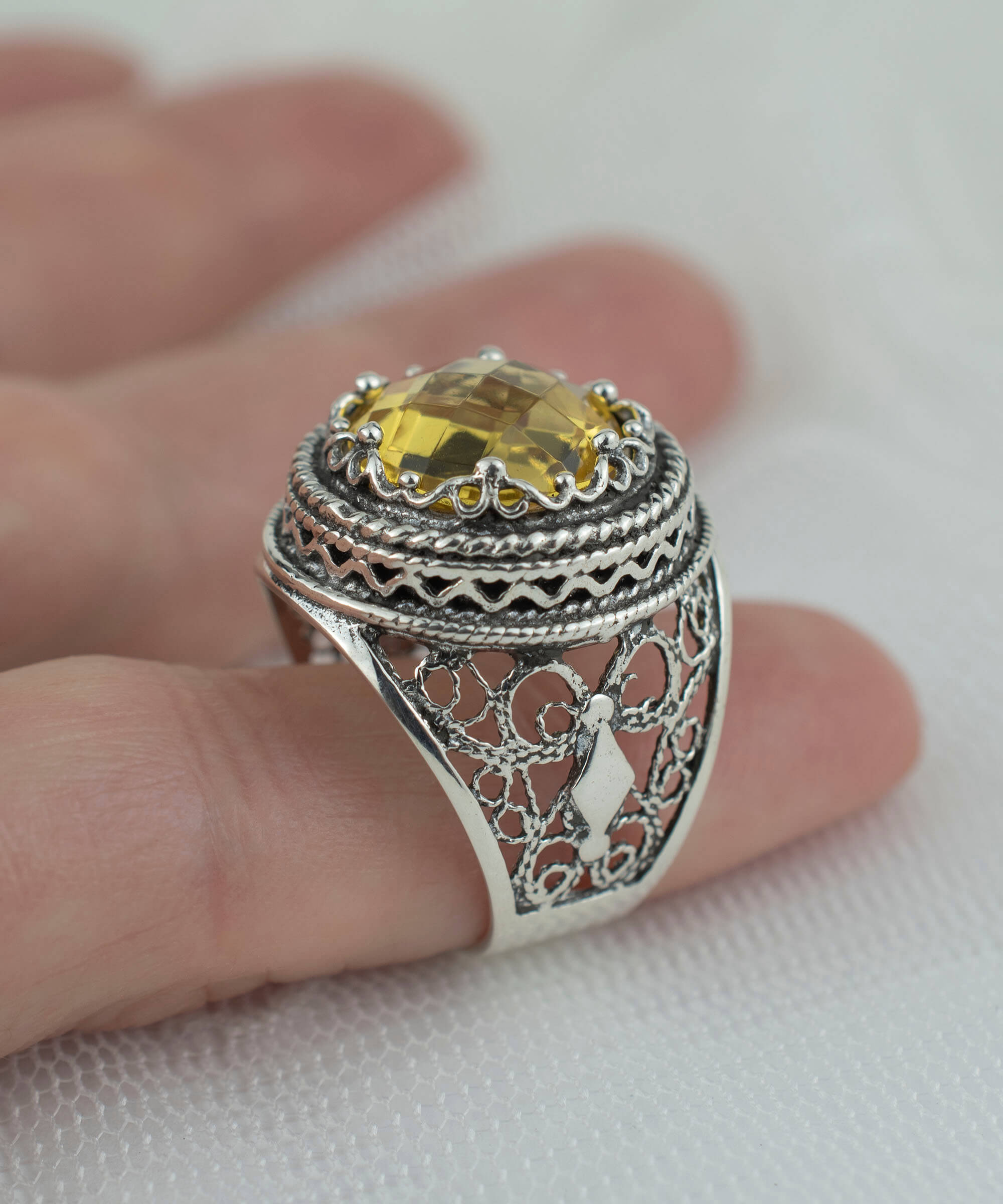 A stunning sterling silver bold ring featuring a 12mm double-sided faceted citrine gemstone, showcasing intricate filigree art design.