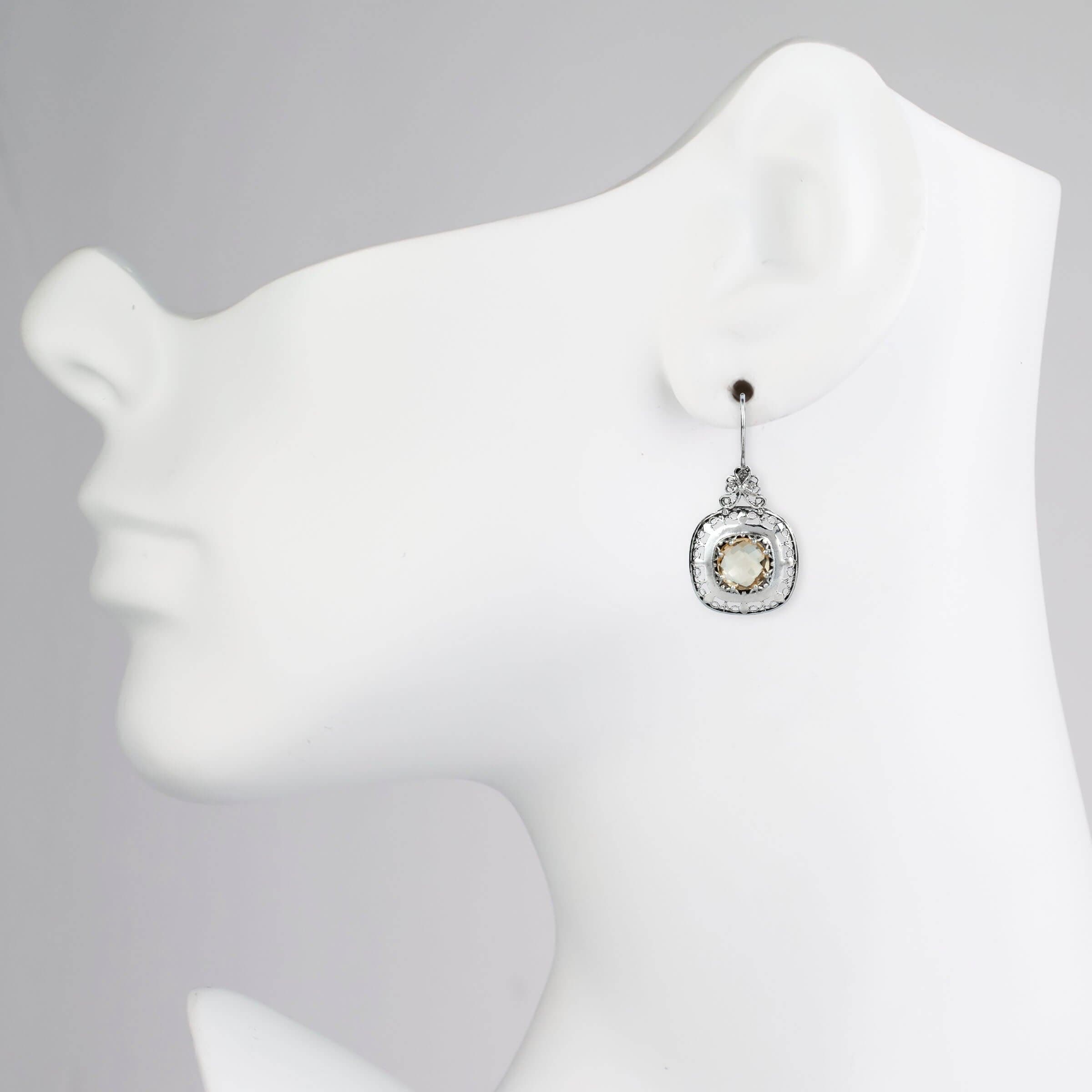 Elegant sterling silver drop earrings featuring intricate filigree design and a vibrant 10mm round-cut citrine gemstone.