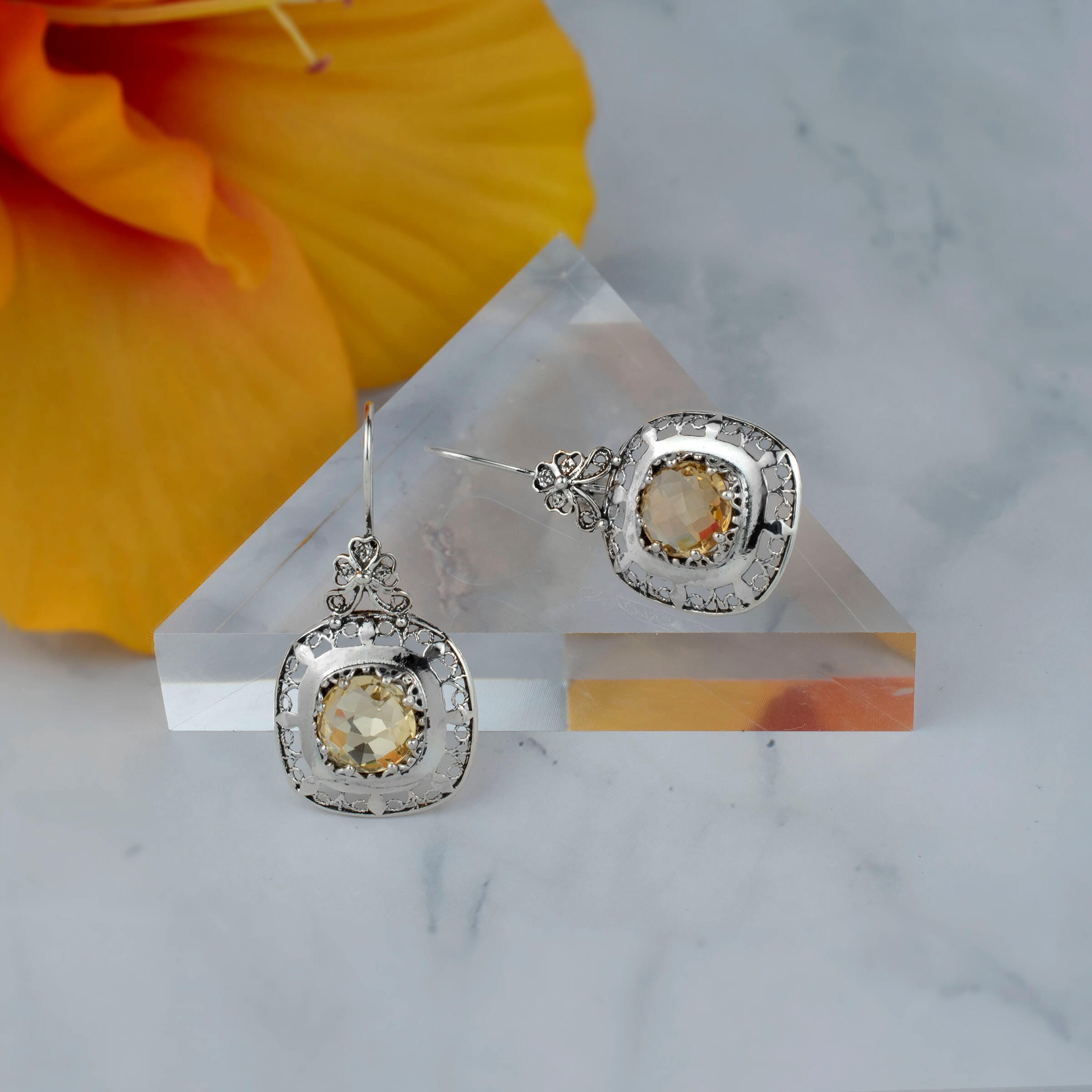 Elegant sterling silver drop earrings featuring intricate filigree design and a vibrant 10mm round-cut citrine gemstone.