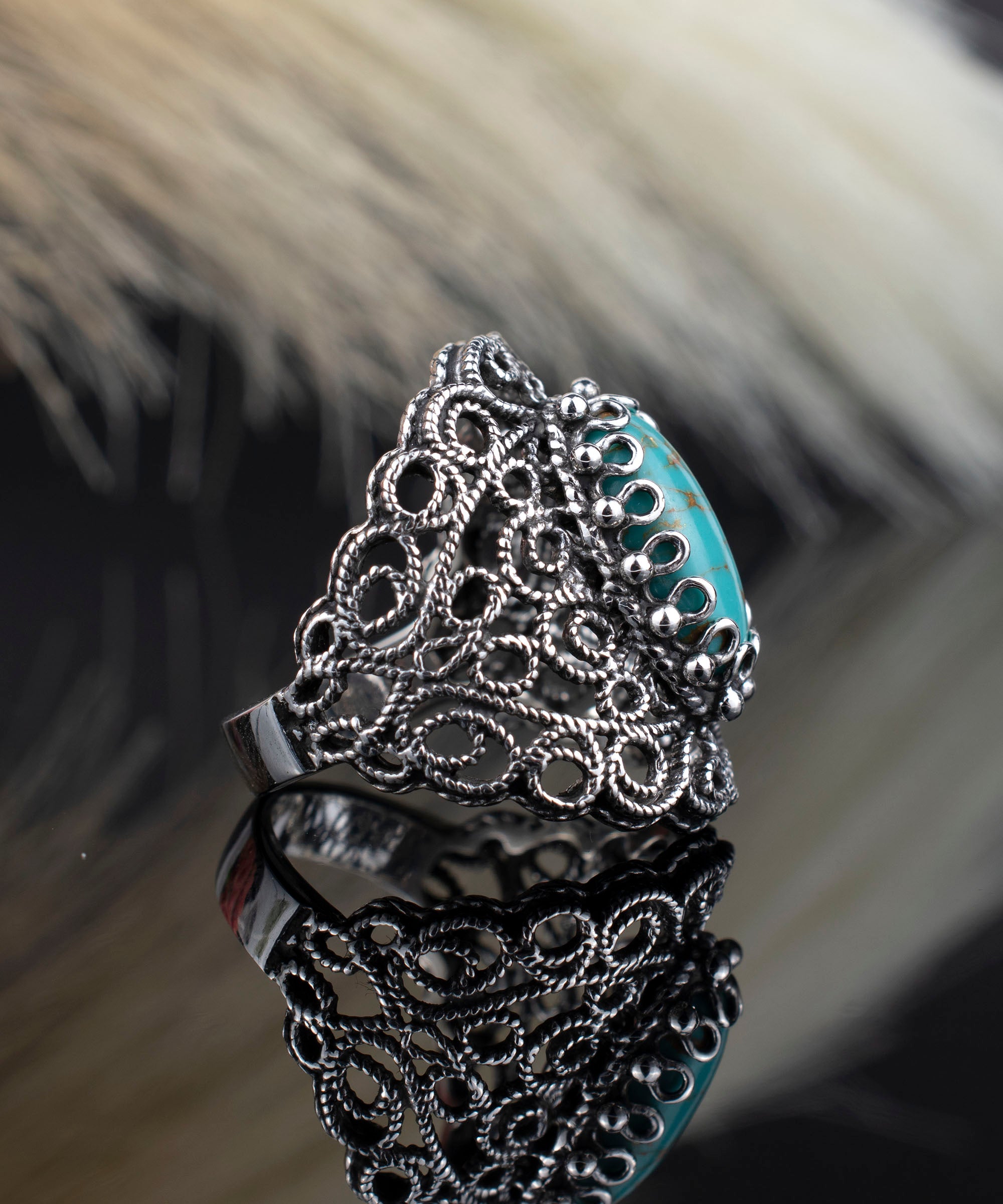 Handmade silver statement ring featuring intricate filigree design and a copper turquoise gemstone centerpiece.