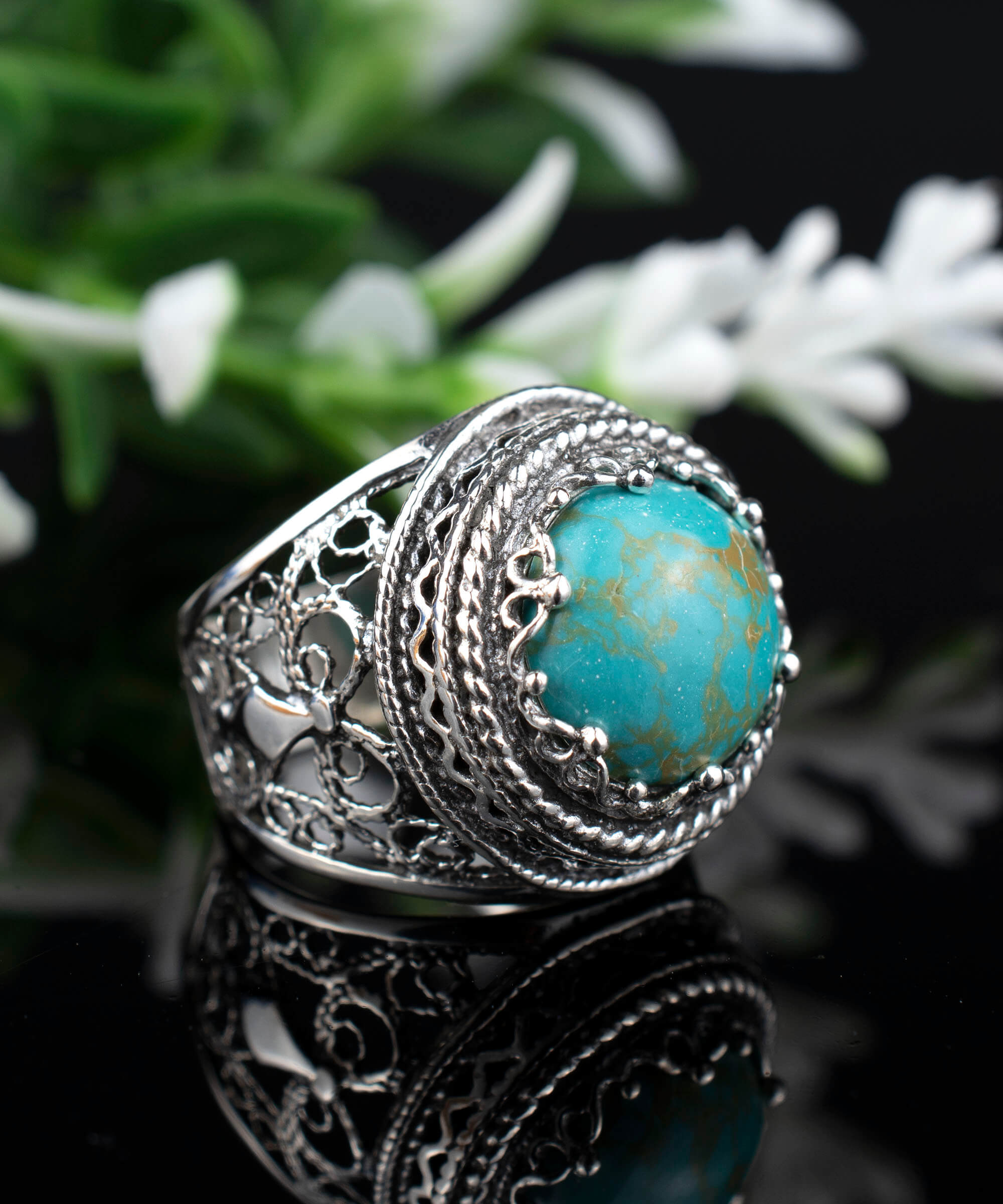 A stunning silver ring featuring intricate filigree art and a round 12mm copper turquoise gemstone, showcasing a blend of modern and traditional design.