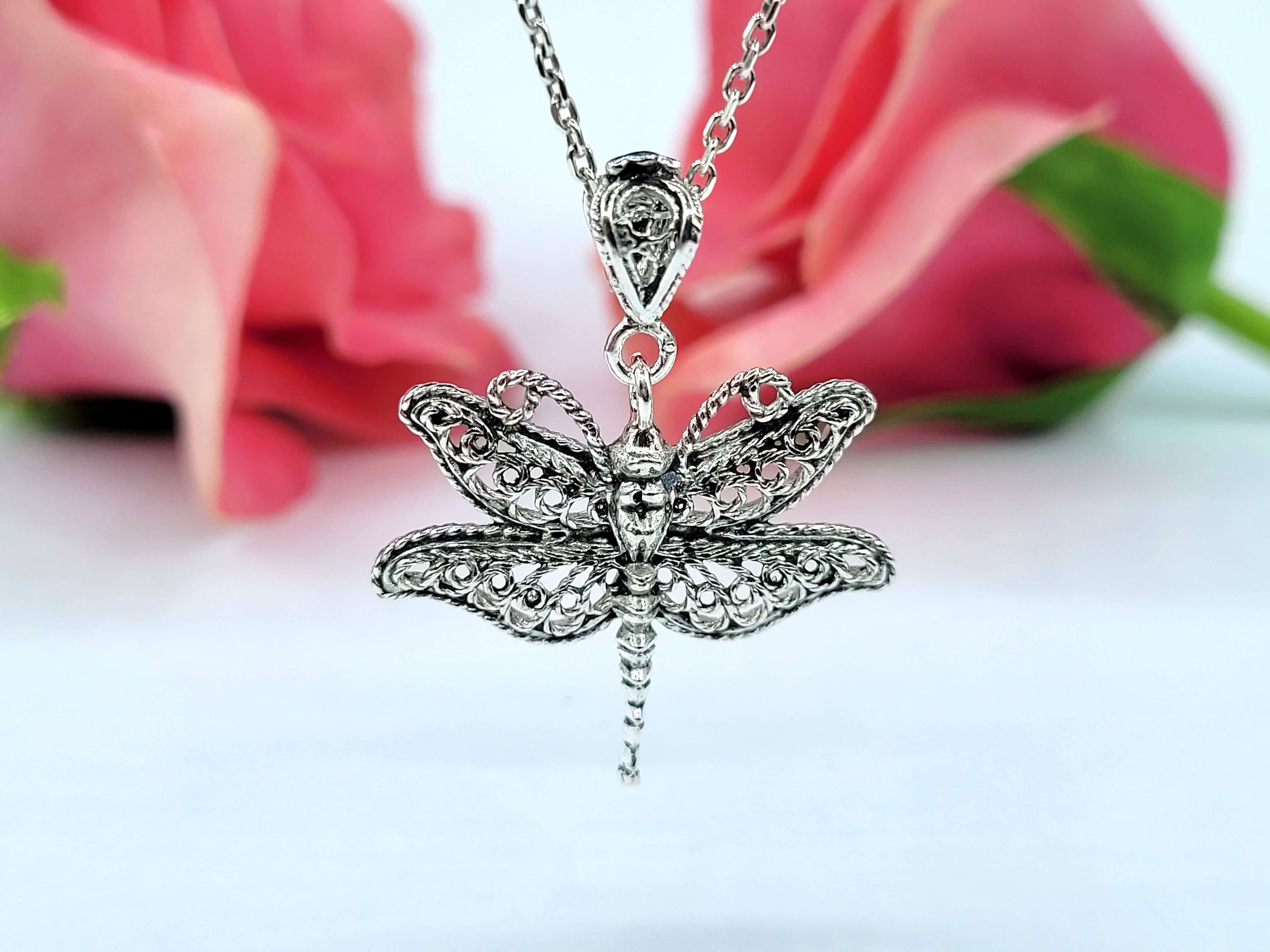 Sterling silver pendant necklace featuring a delicate filigree dragonfly design, showcasing intricate craftsmanship.