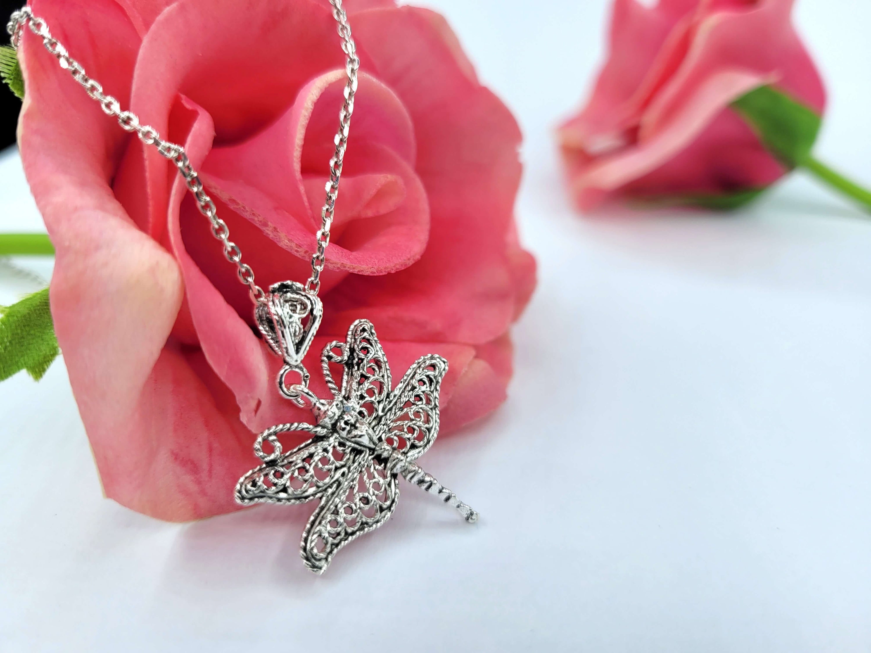 Sterling silver pendant necklace featuring a delicate filigree dragonfly design, showcasing intricate craftsmanship.