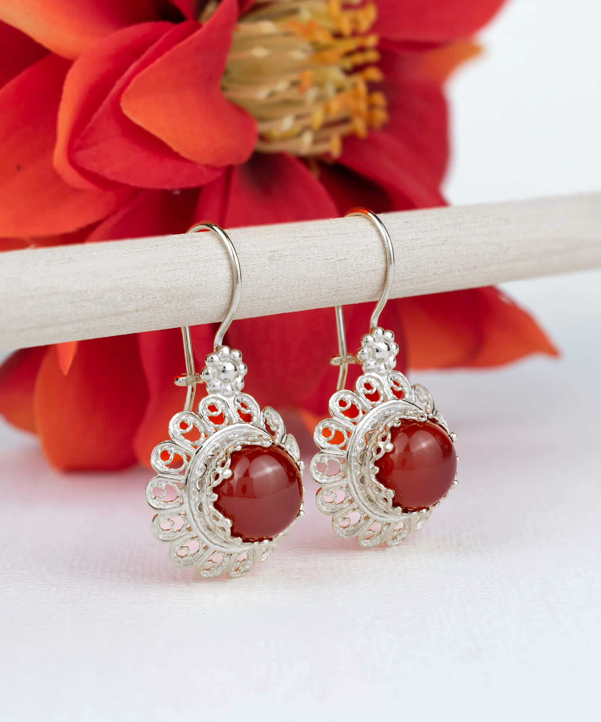 Handmade silver drop earrings featuring a filigree flower design and vibrant ruby quartz gemstone.