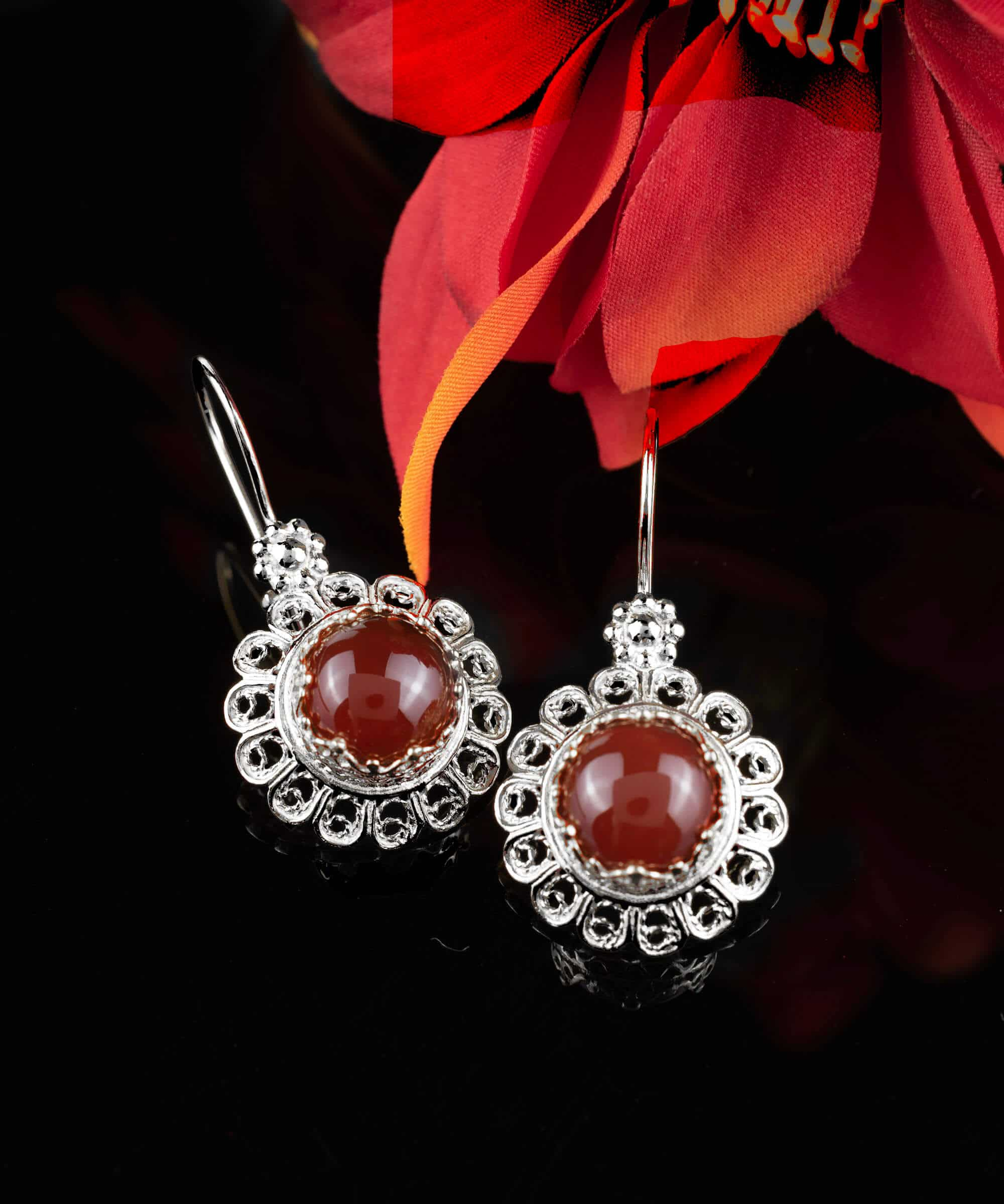 Handmade silver drop earrings featuring a filigree flower design and vibrant ruby quartz gemstone.