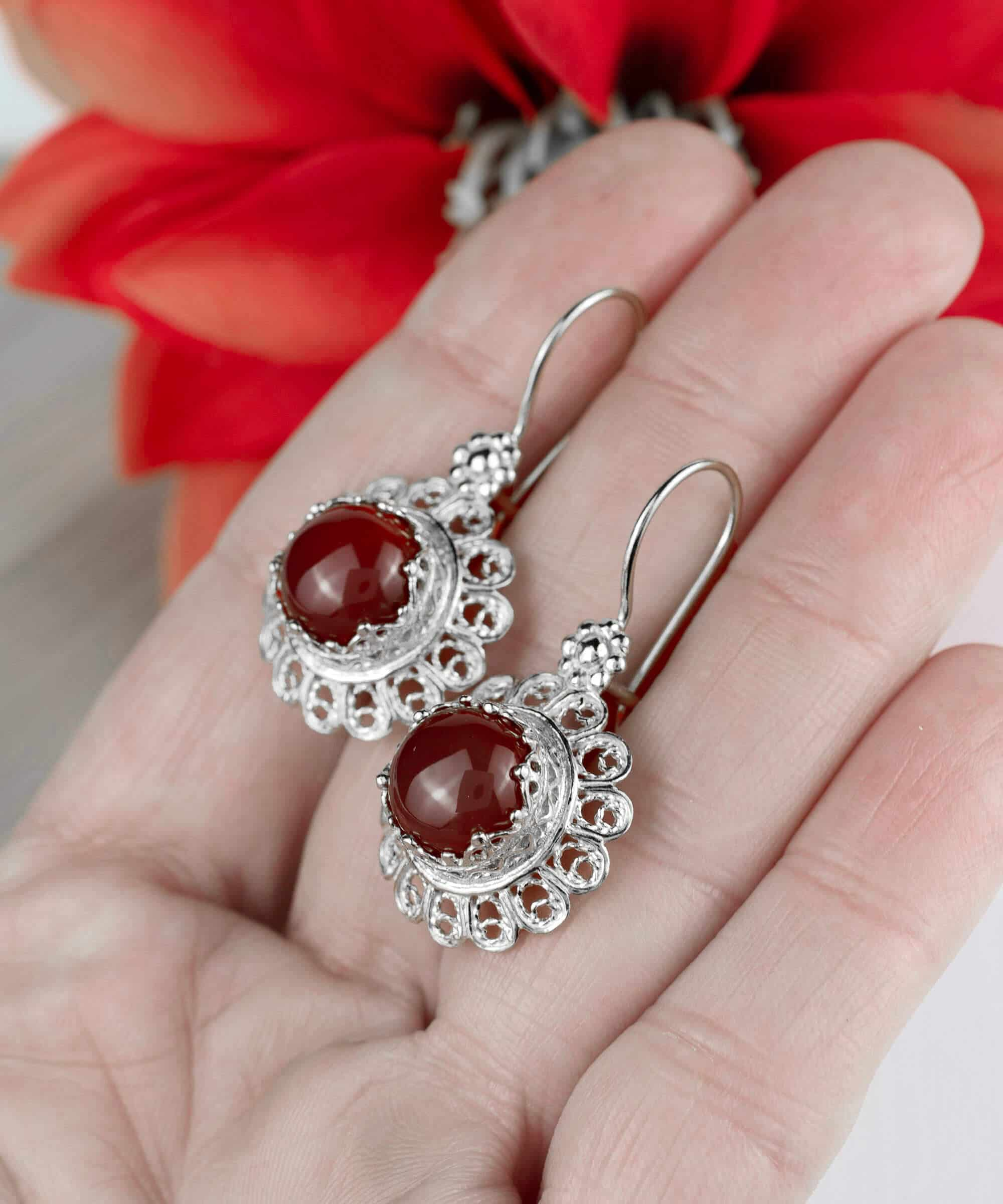 Handmade silver drop earrings featuring a filigree flower design and vibrant ruby quartz gemstone.