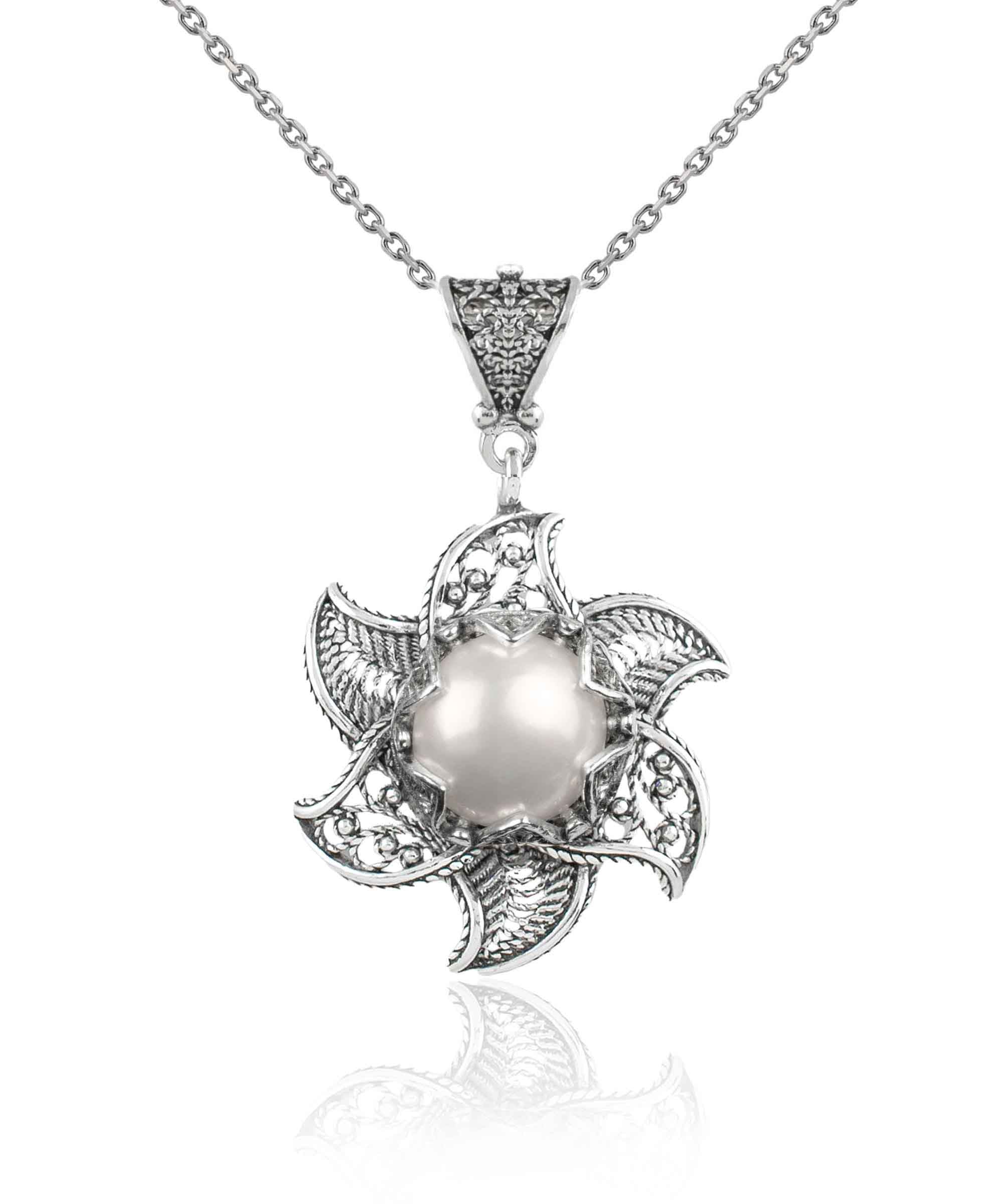 A stunning silver necklace featuring a blossoming lotus flower pendant with a central freshwater pearl, elegantly designed in filigree art.