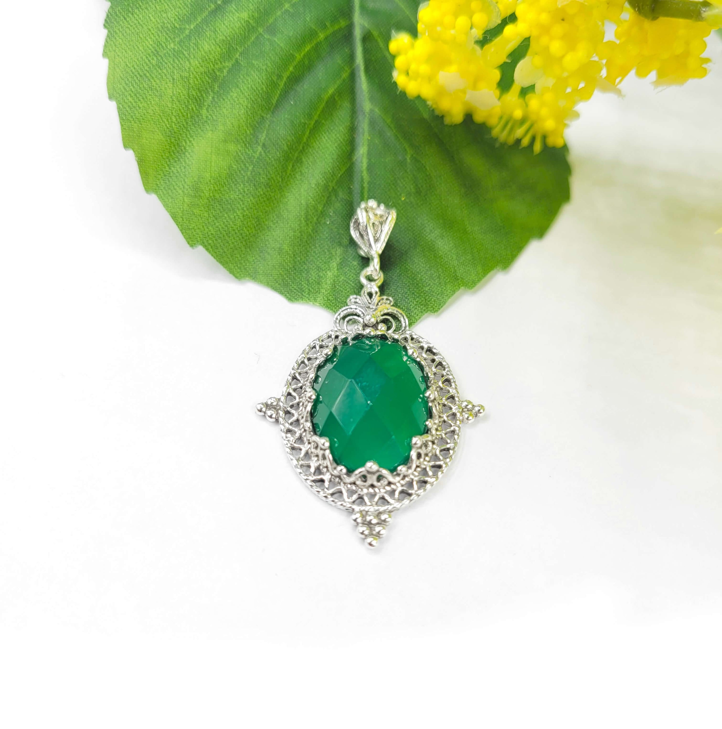 Elegant silver oval pendant necklace featuring a green agate gemstone with intricate filigree design.