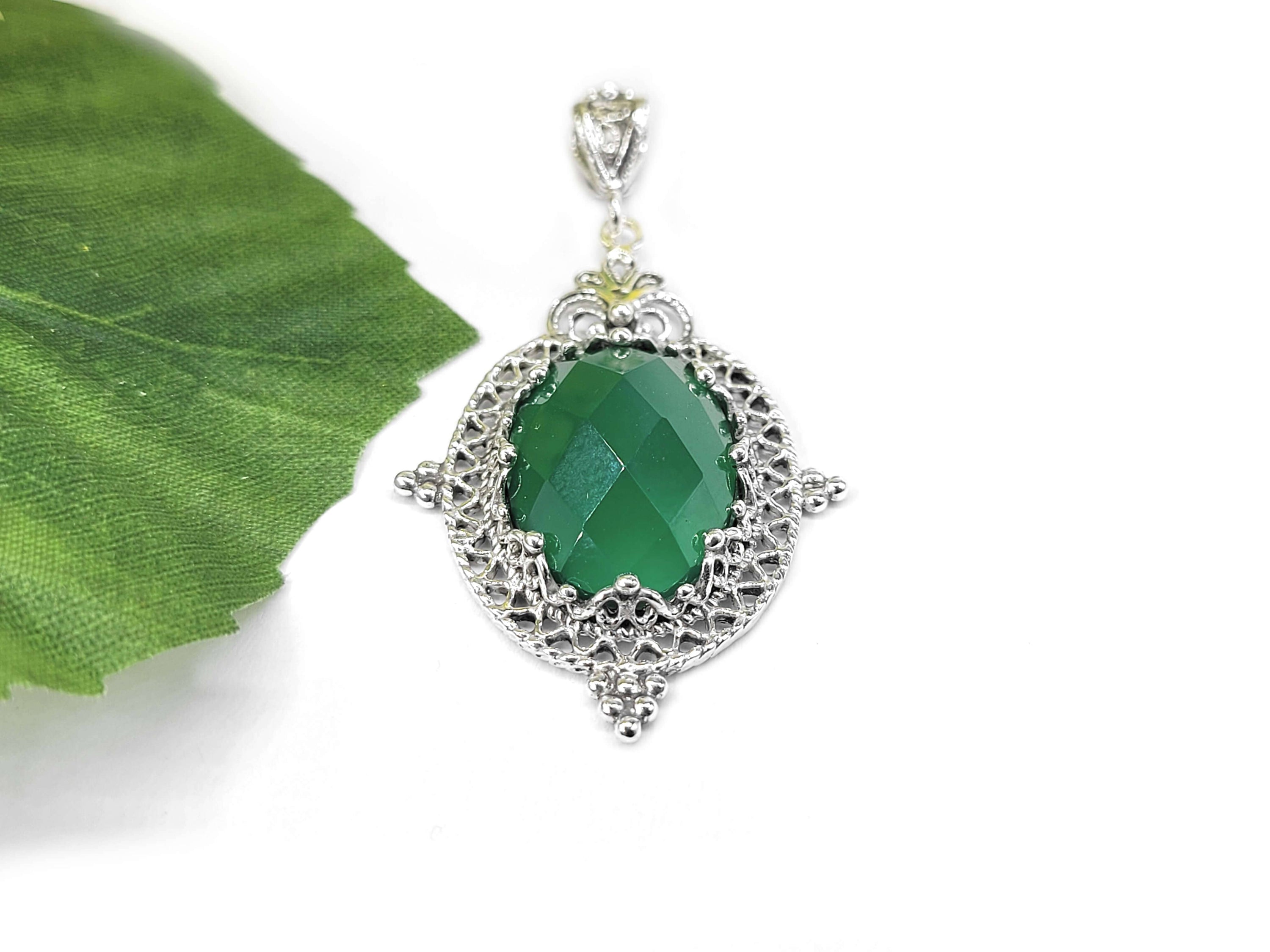 Elegant silver oval pendant necklace featuring a green agate gemstone with intricate filigree design.