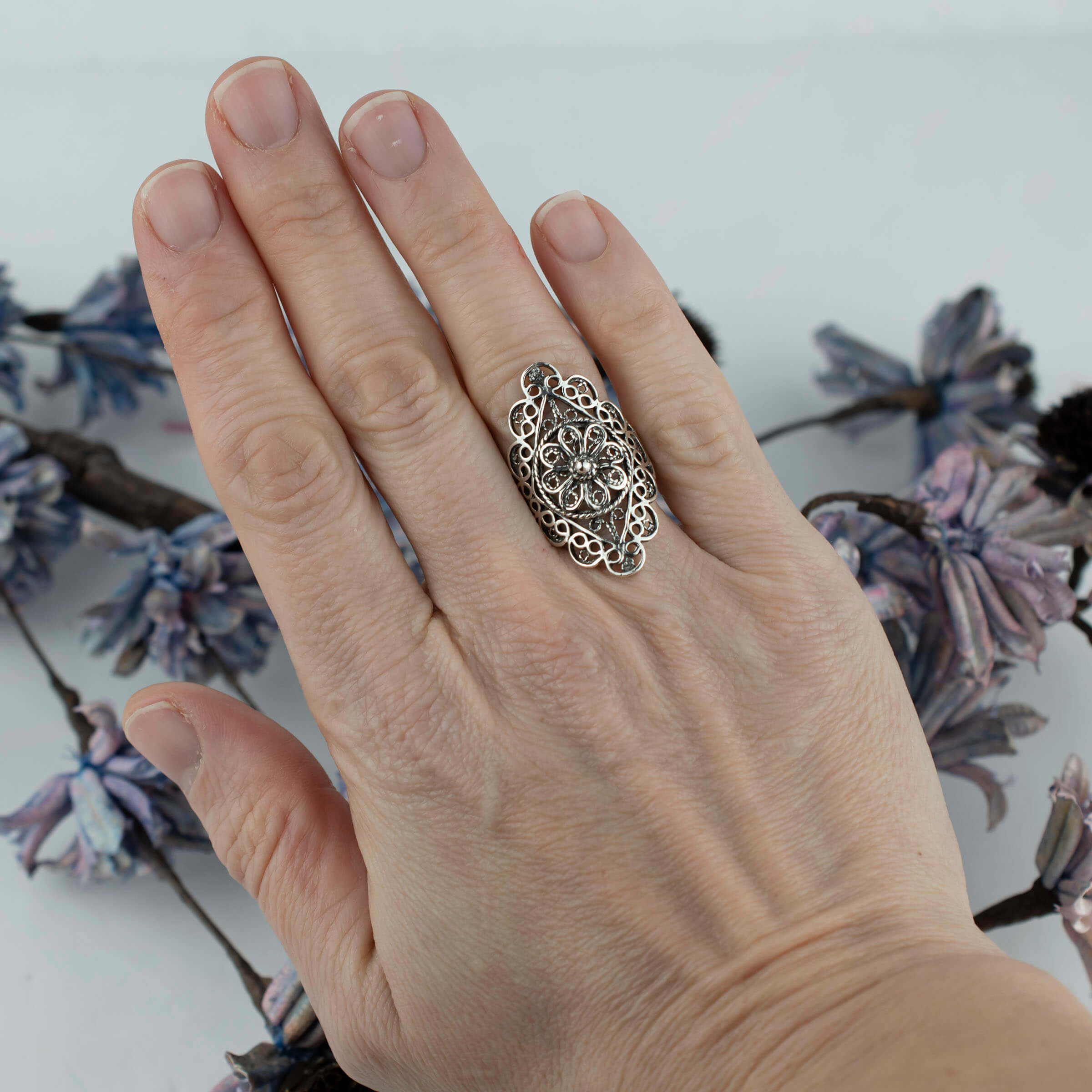 A stunning silver statement ring featuring intricate filigree and lace embroidery, showcasing timeless elegance and craftsmanship.