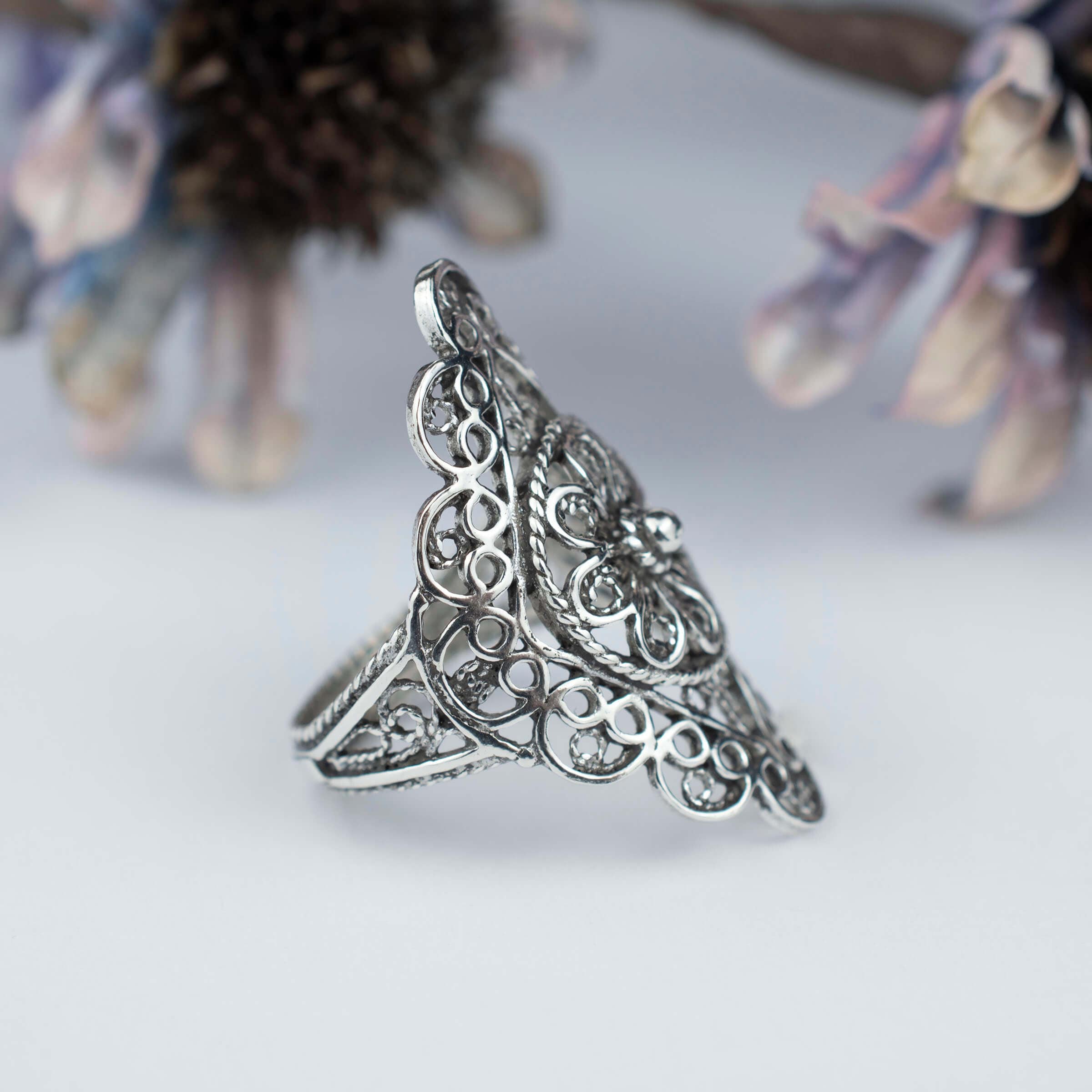 A stunning silver statement ring featuring intricate filigree and lace embroidery, showcasing timeless elegance and craftsmanship.