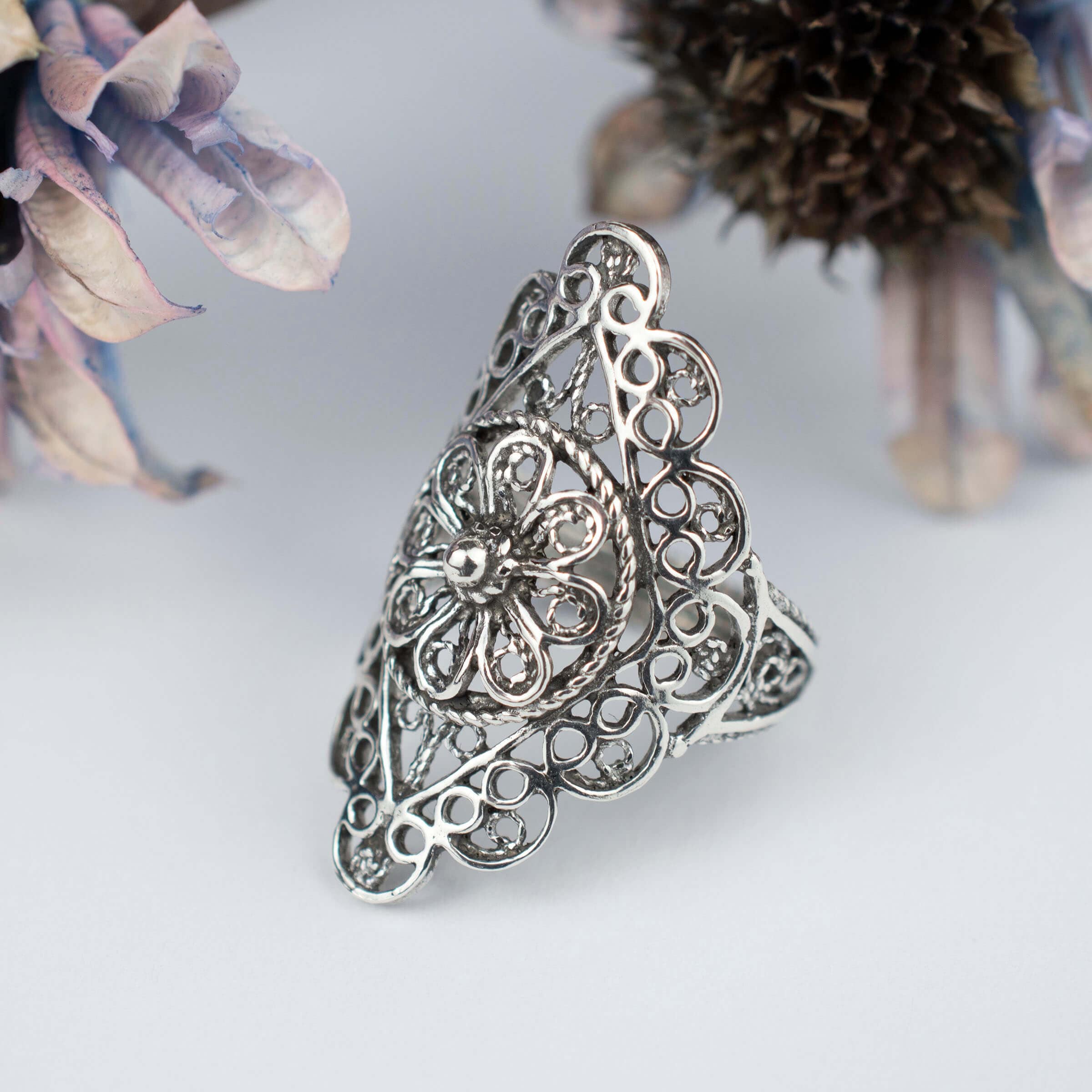 A stunning silver statement ring featuring intricate filigree and lace embroidery, showcasing timeless elegance and craftsmanship.