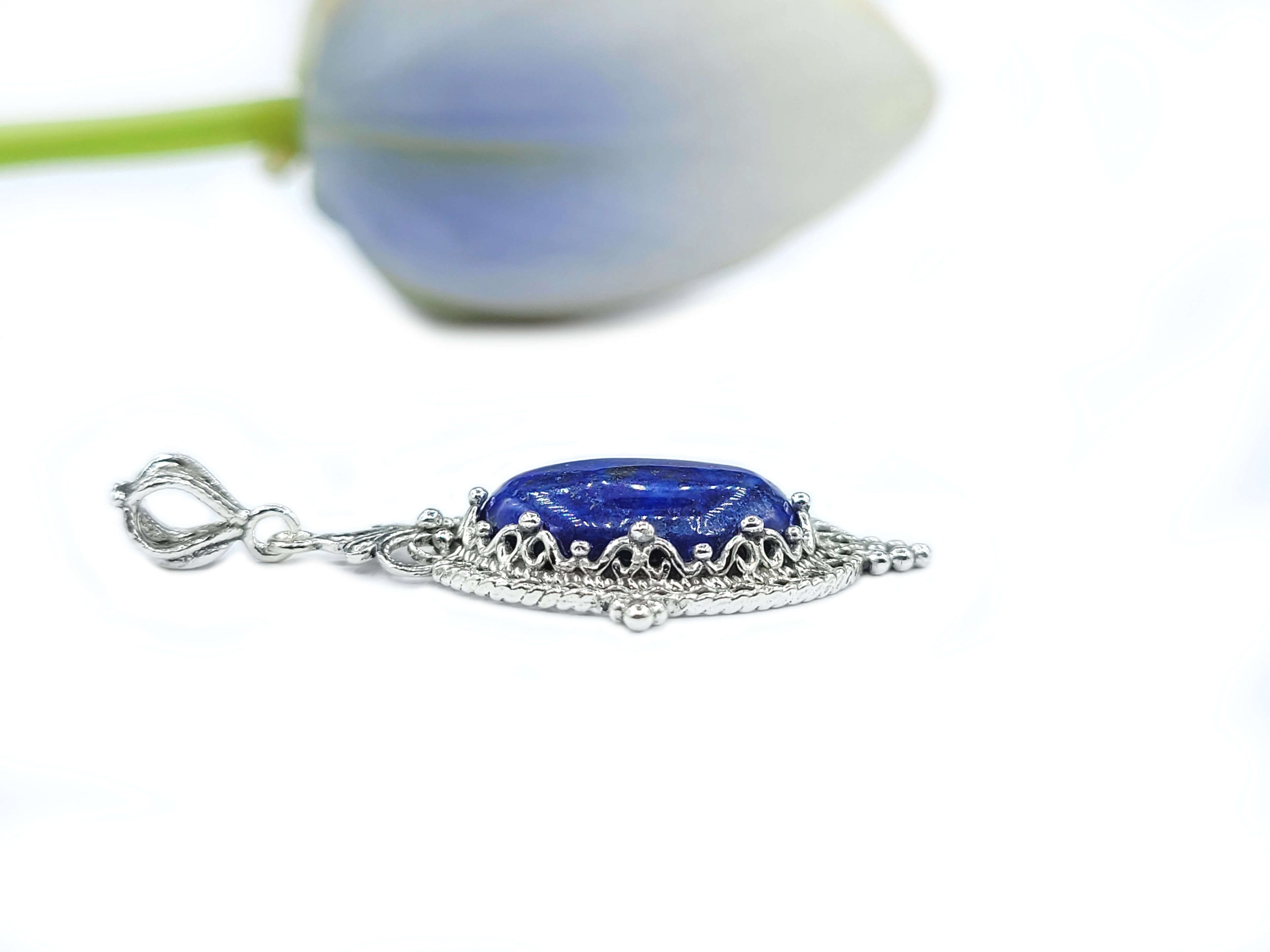 Elegant sterling silver filigree pendant necklace featuring a natural lapis lazuli gemstone in an oval shape.