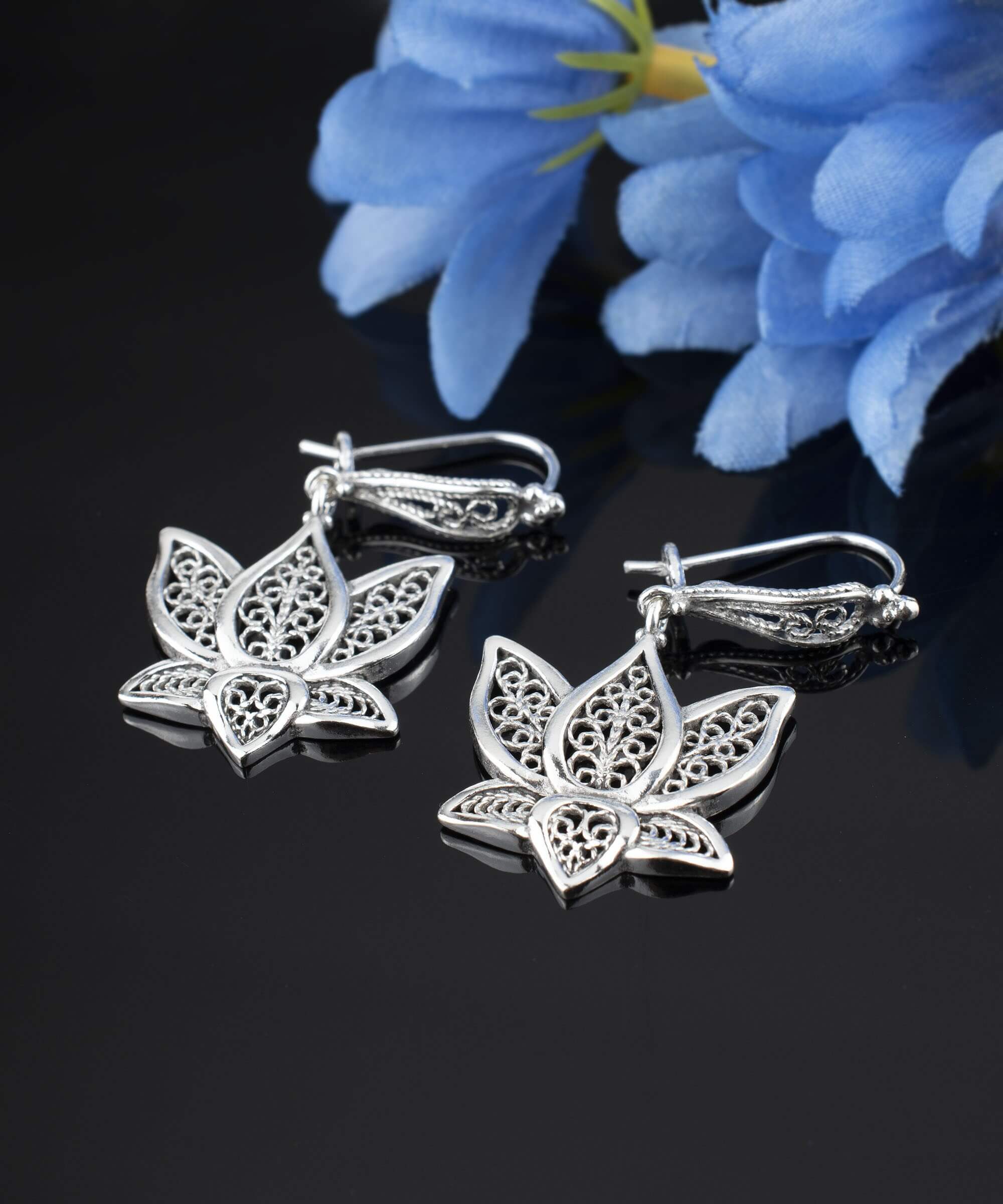 Elegant silver dangle drop earrings featuring intricate filigree art inspired by the lotus flower, showcasing craftsmanship and beauty.