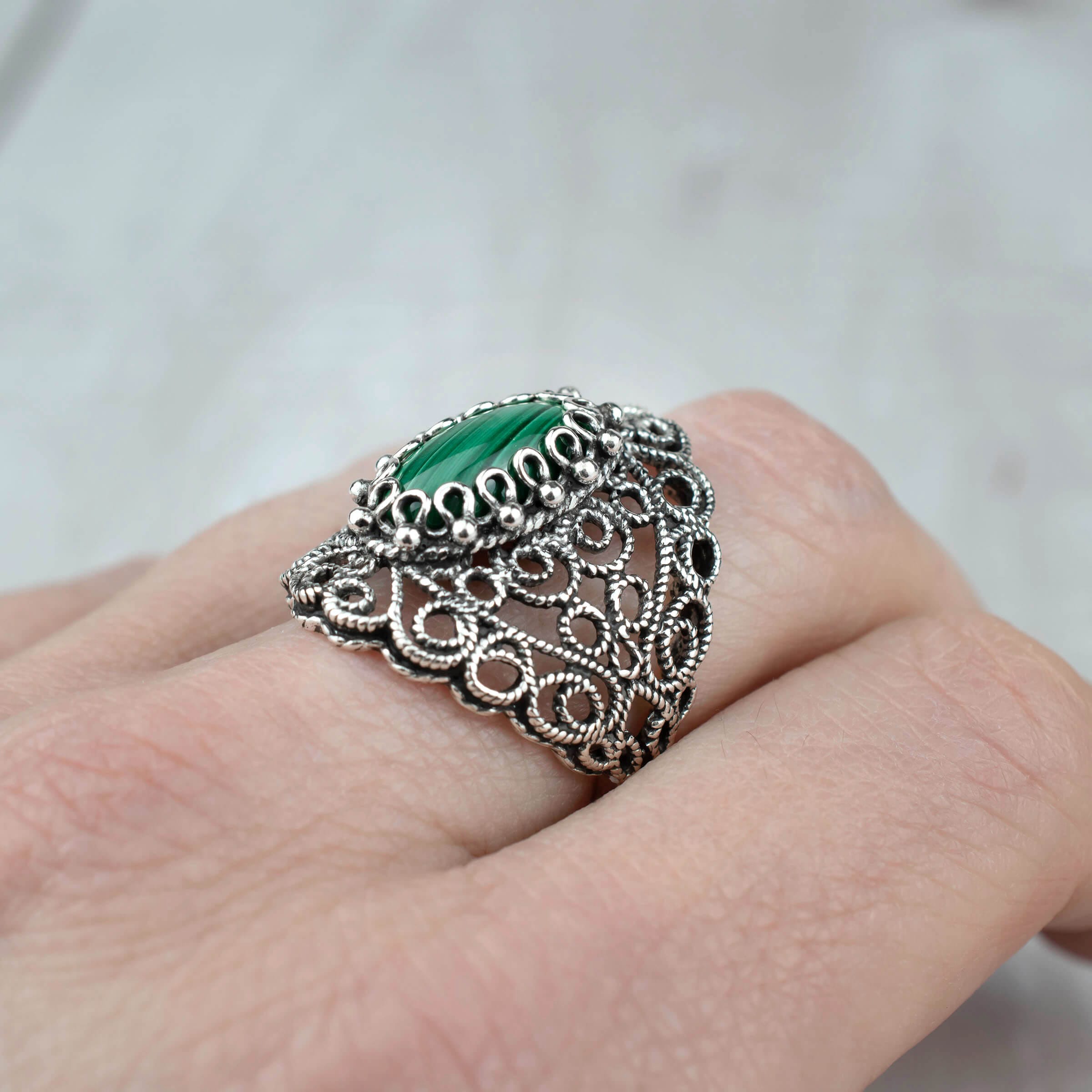 Handmade silver statement ring featuring a malachite gemstone with intricate filigree lace detailing, showcasing elegance and craftsmanship.