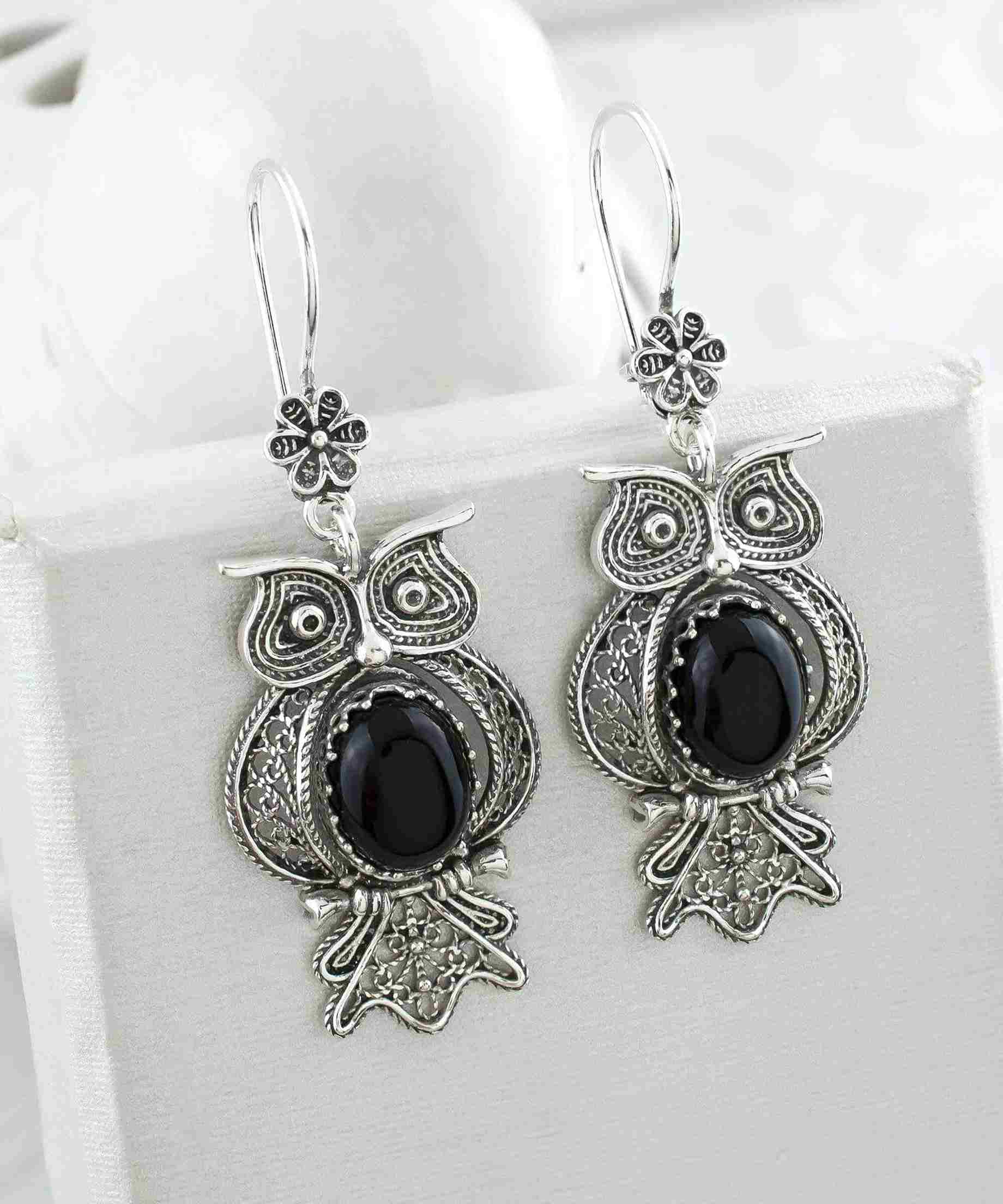 Elegant silver dangle earrings featuring an owl design with intricate filigree work and a central Black Onyx gemstone.