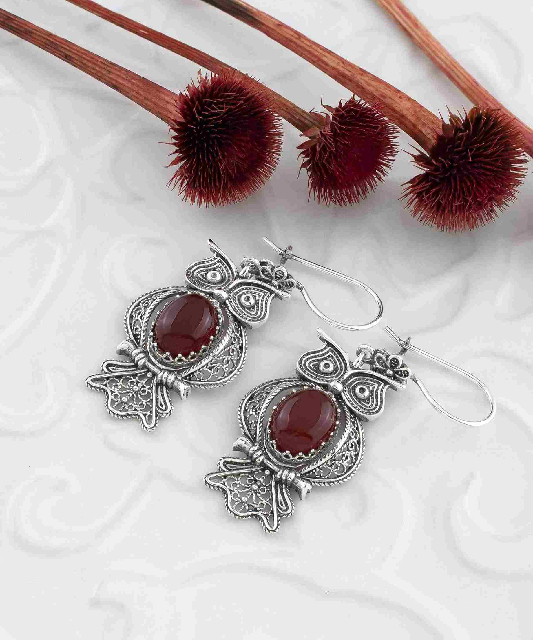 Elegant owl-shaped dangle earrings made of 925 sterling silver with intricate filigree design and a vibrant Carnelian gemstone centerpiece.