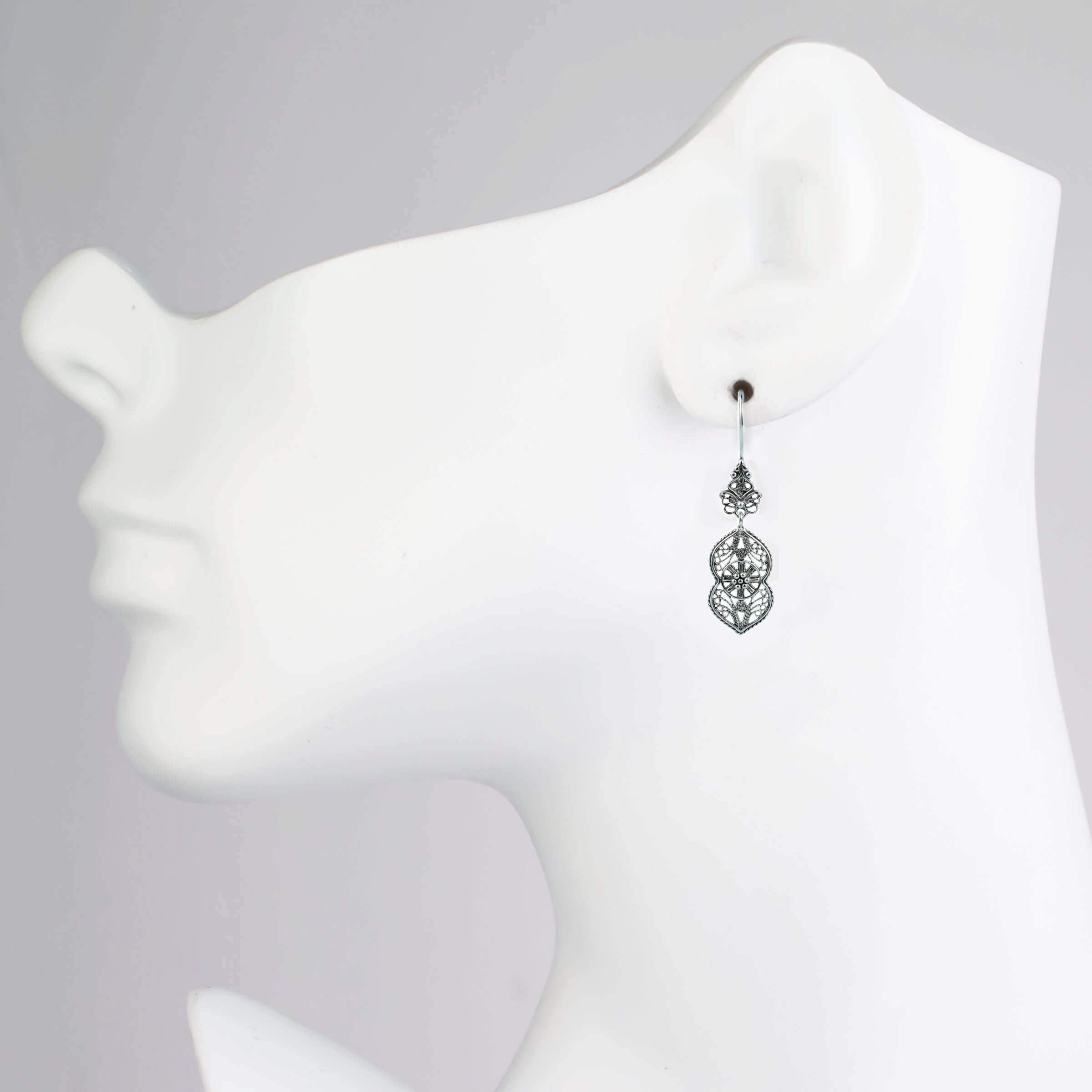 Elegant sterling silver dangle drop earrings featuring intricate paisley filigree design, showcasing a vintage look and polished shine.