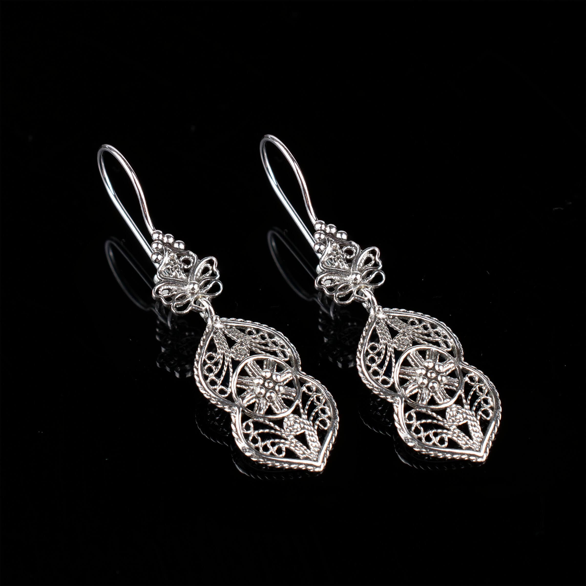 Elegant sterling silver dangle drop earrings featuring intricate paisley filigree design, showcasing a vintage look and polished shine.