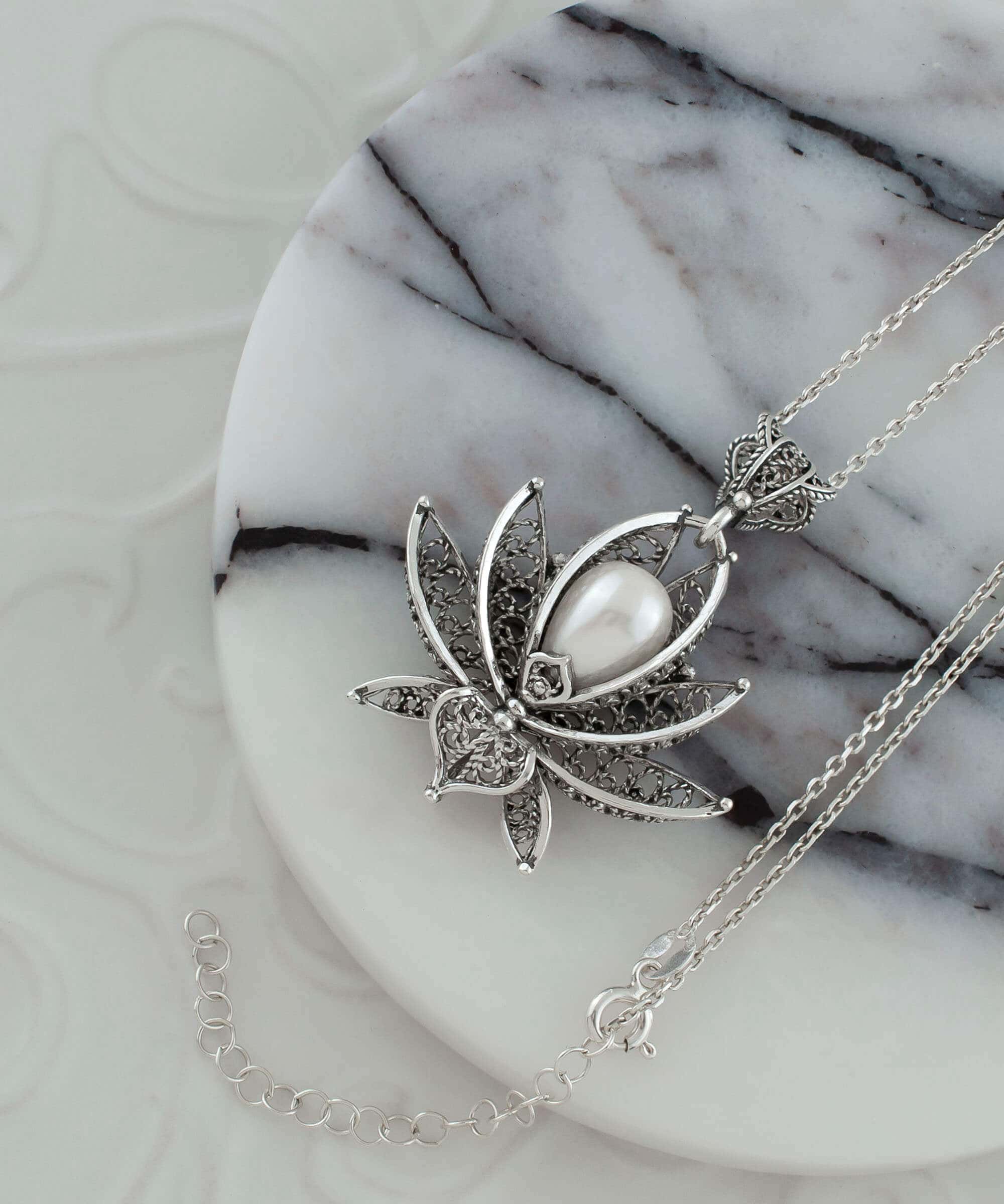 A beautifully crafted 3D lotus flower pendant made of 925 Sterling Silver with a cultured freshwater pearl, showcasing intricate filigree details.