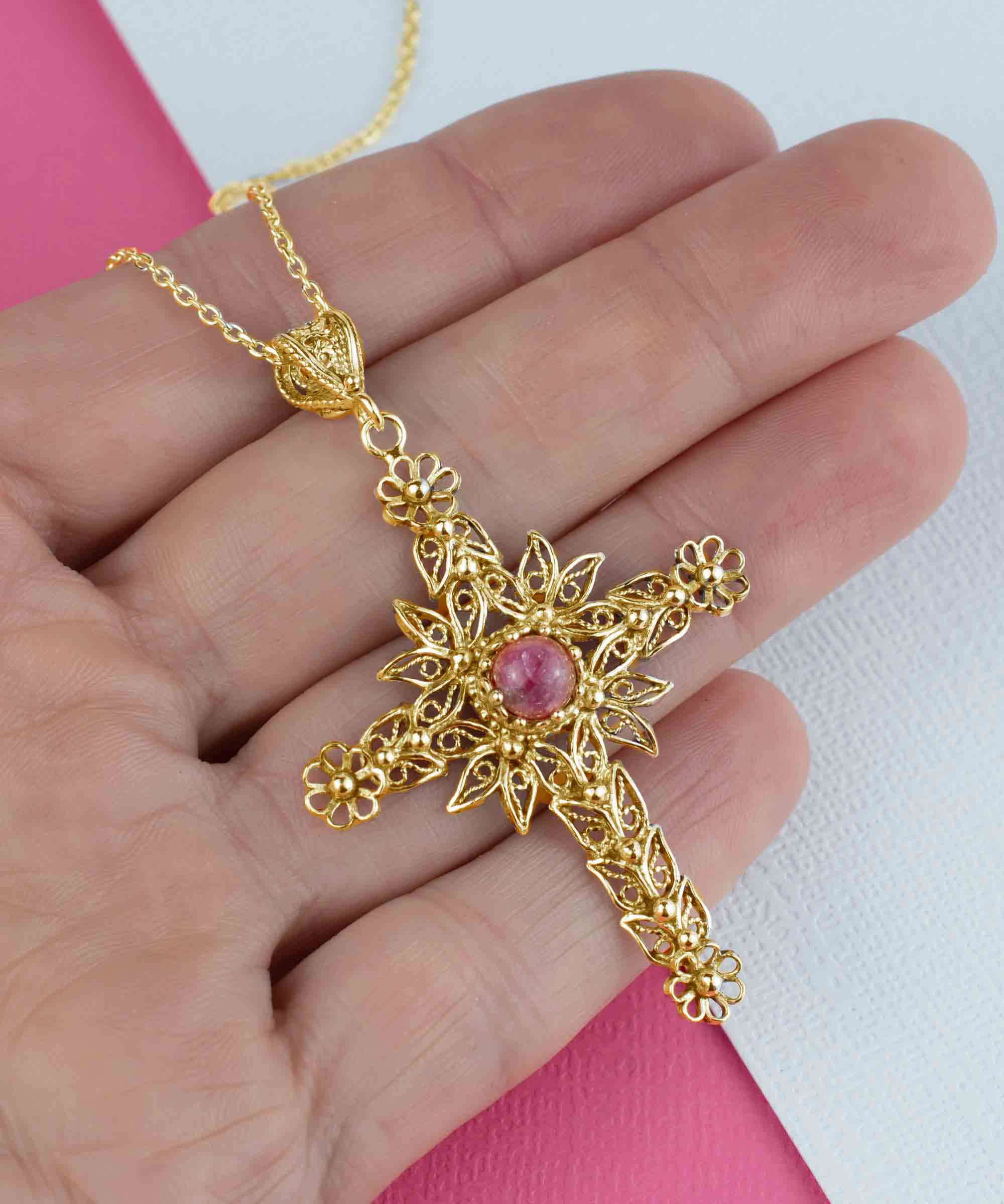 Gold plated silver cross pendant featuring a Rhodonite gemstone with intricate filigree art design.