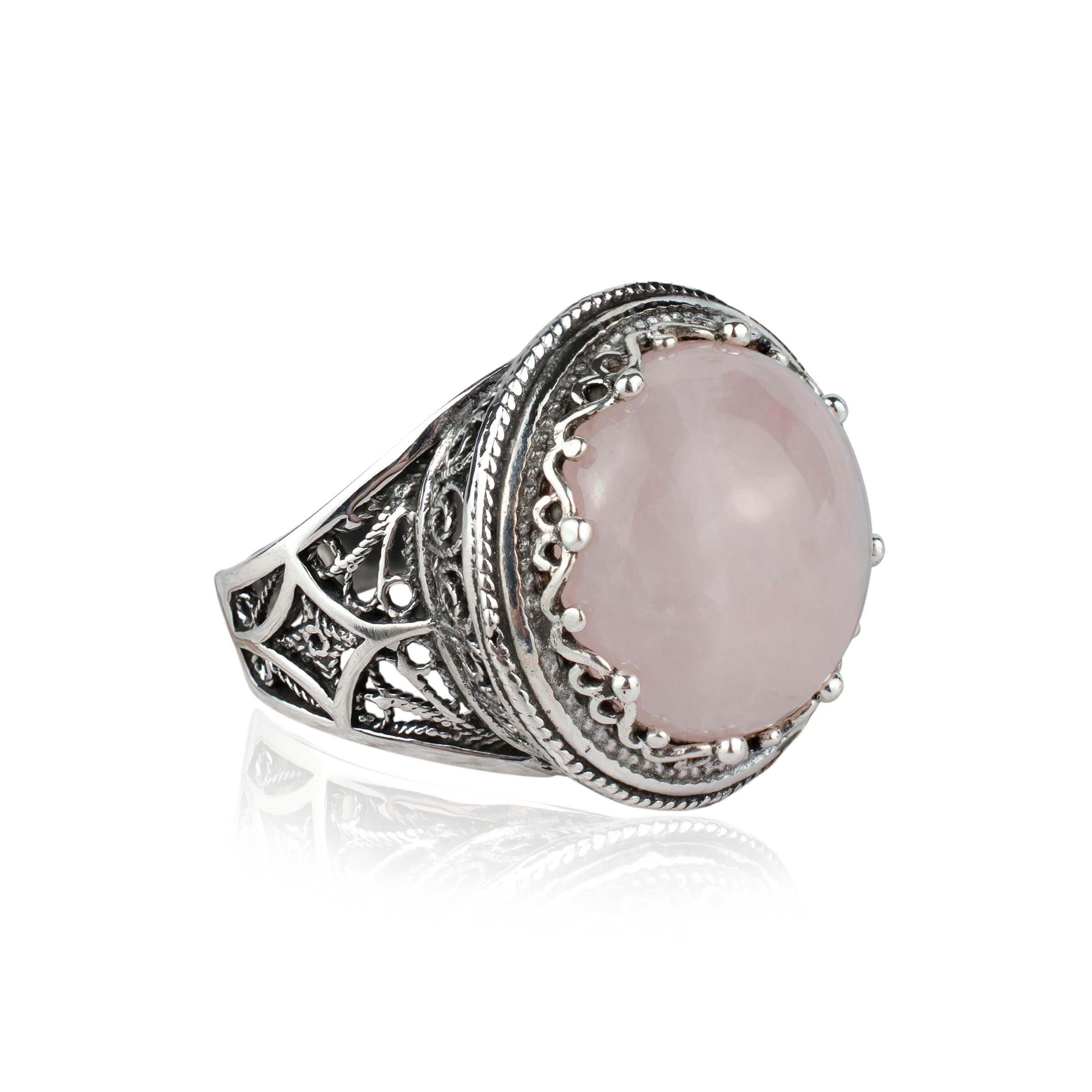 A stunning sterling silver filigree ring featuring a round cut rose quartz gemstone, showcasing intricate metalwork and a polished finish.