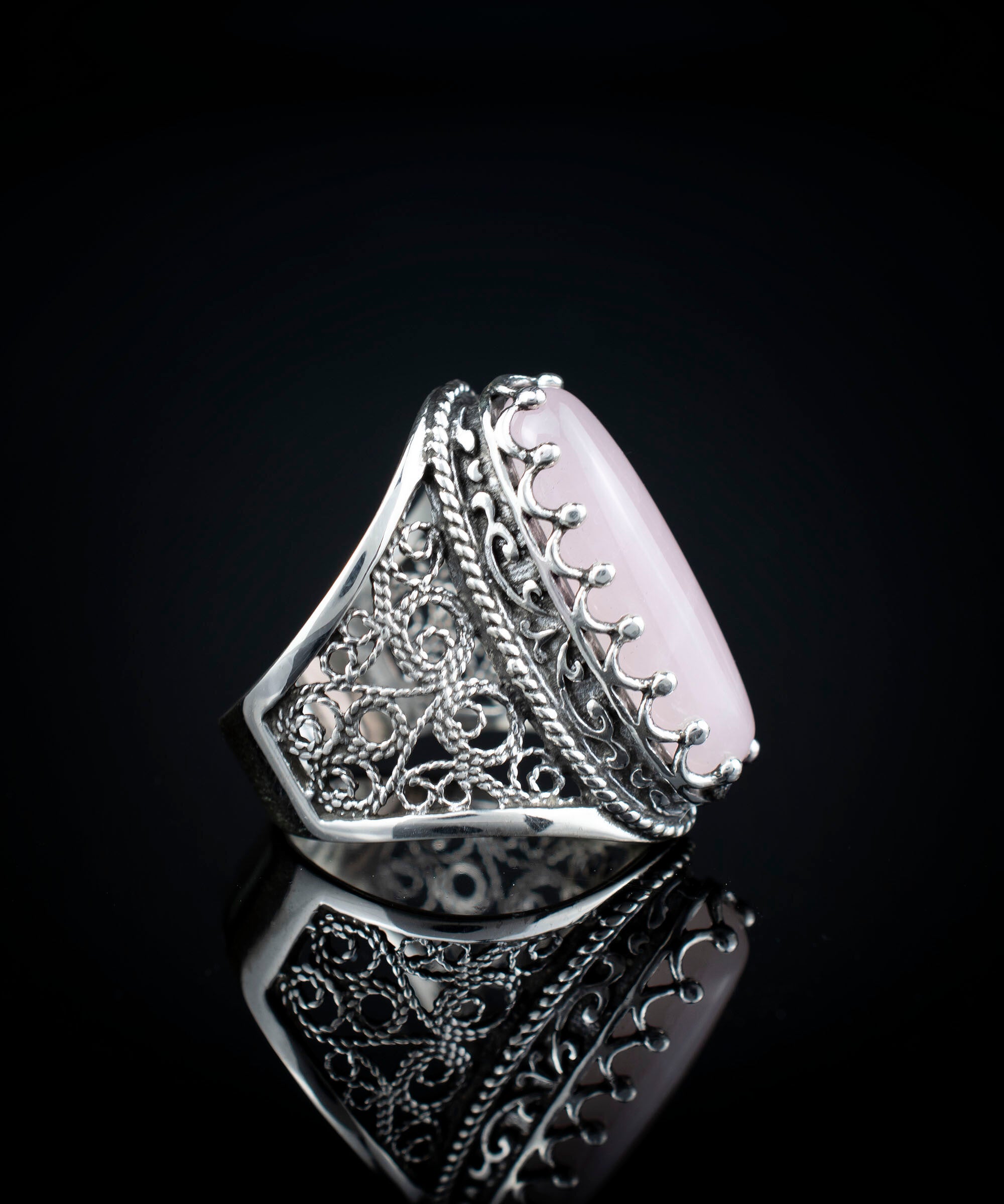 A stunning long statement ring featuring a natural rose quartz gemstone set in intricately designed sterling silver filigree.