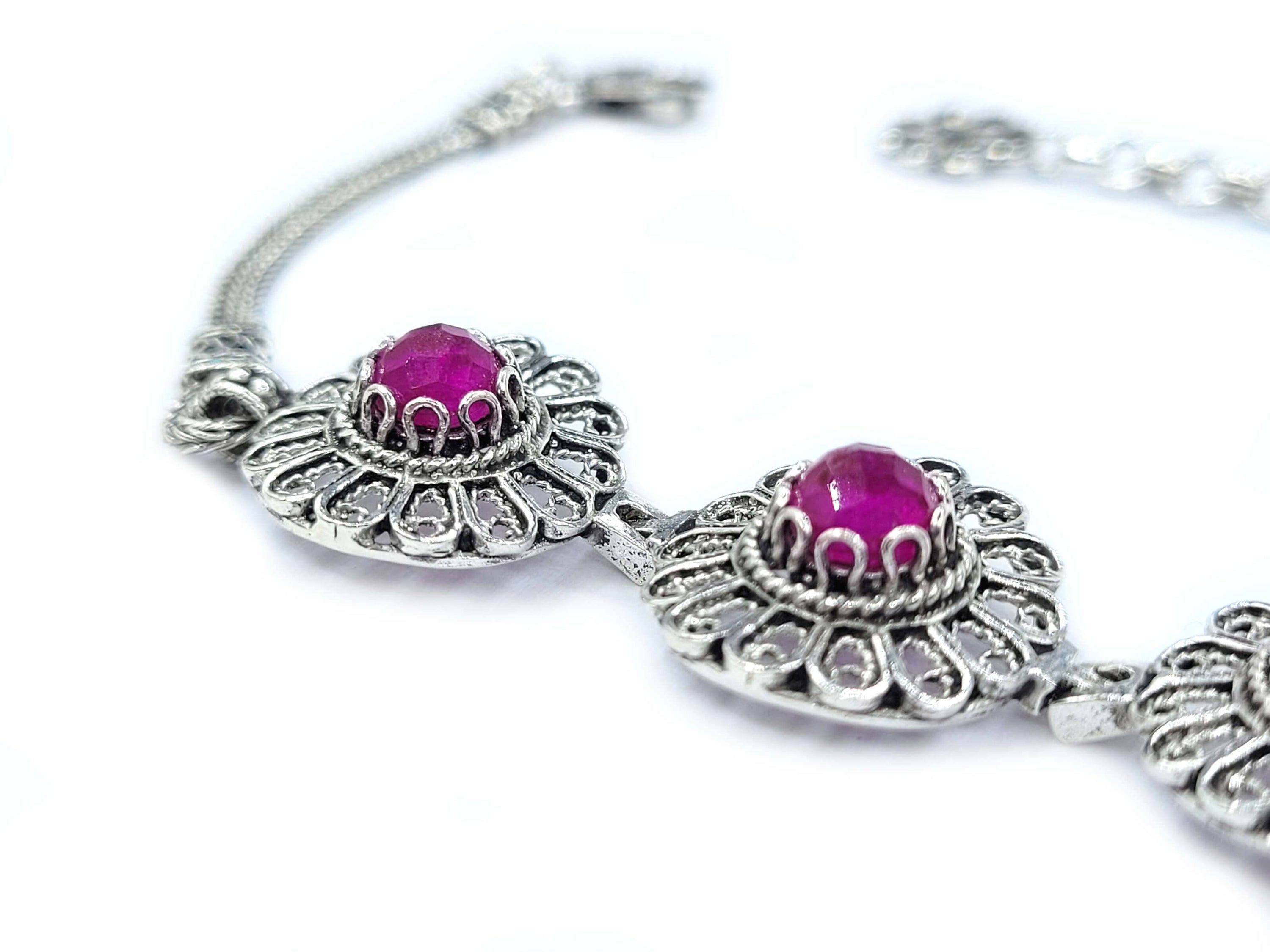 Elegant sterling silver link bracelet featuring filigree art and ruby corundum gemstones, perfect for women.