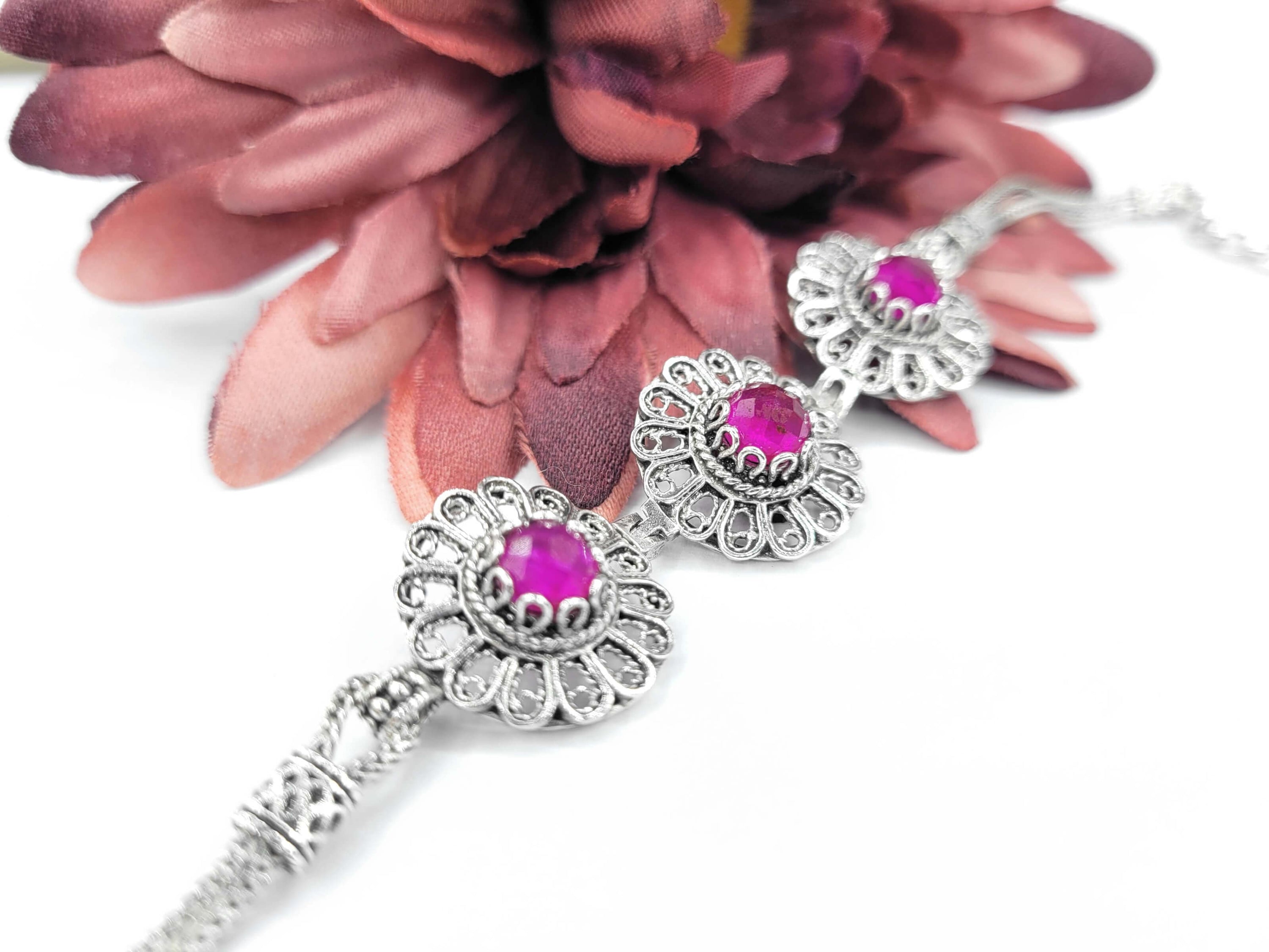 Elegant sterling silver link bracelet featuring filigree art and ruby corundum gemstones, perfect for women.