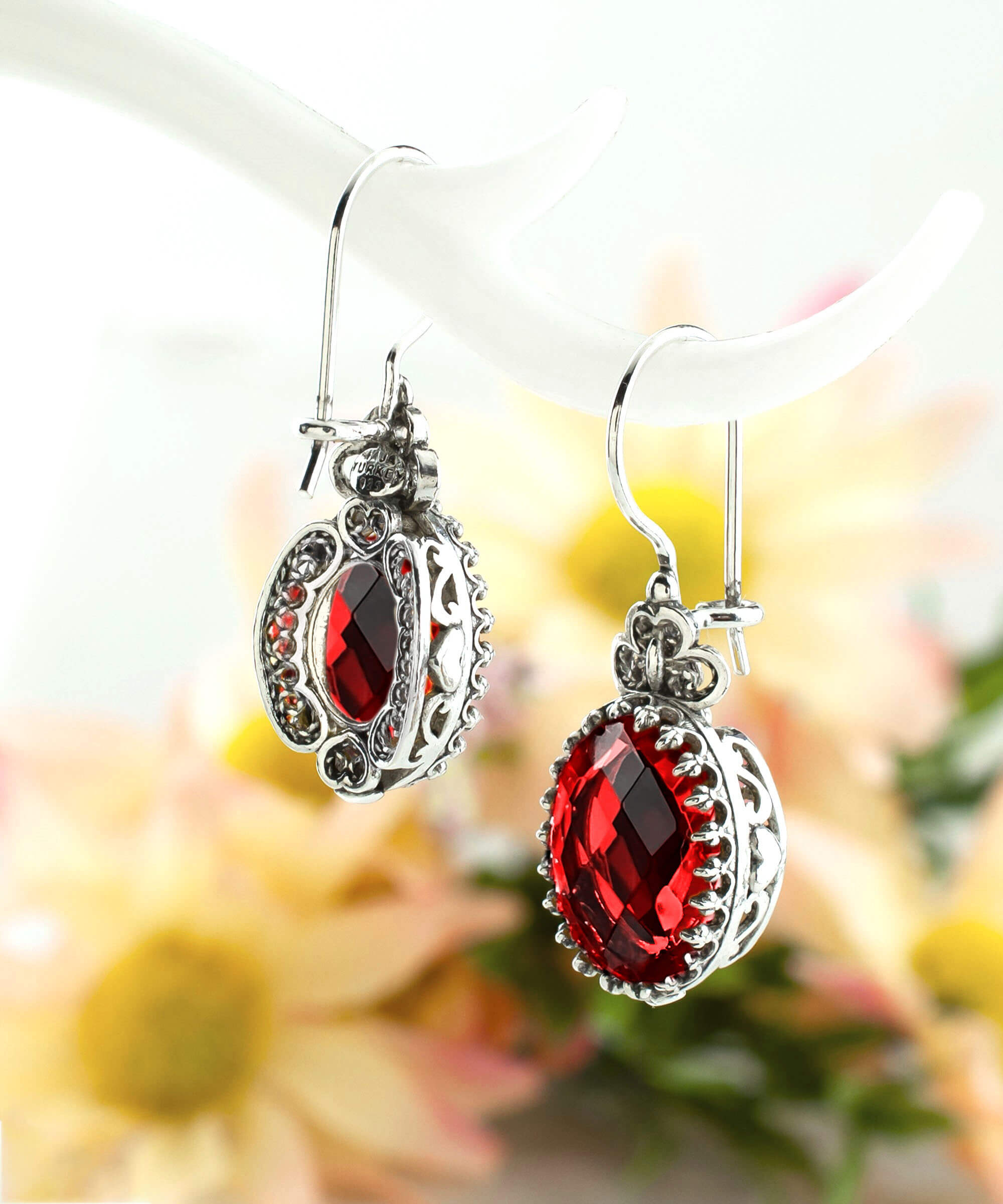 Elegant silver earrings featuring intricate filigree art and a vibrant Ruby Quartz gemstone in a heart design.