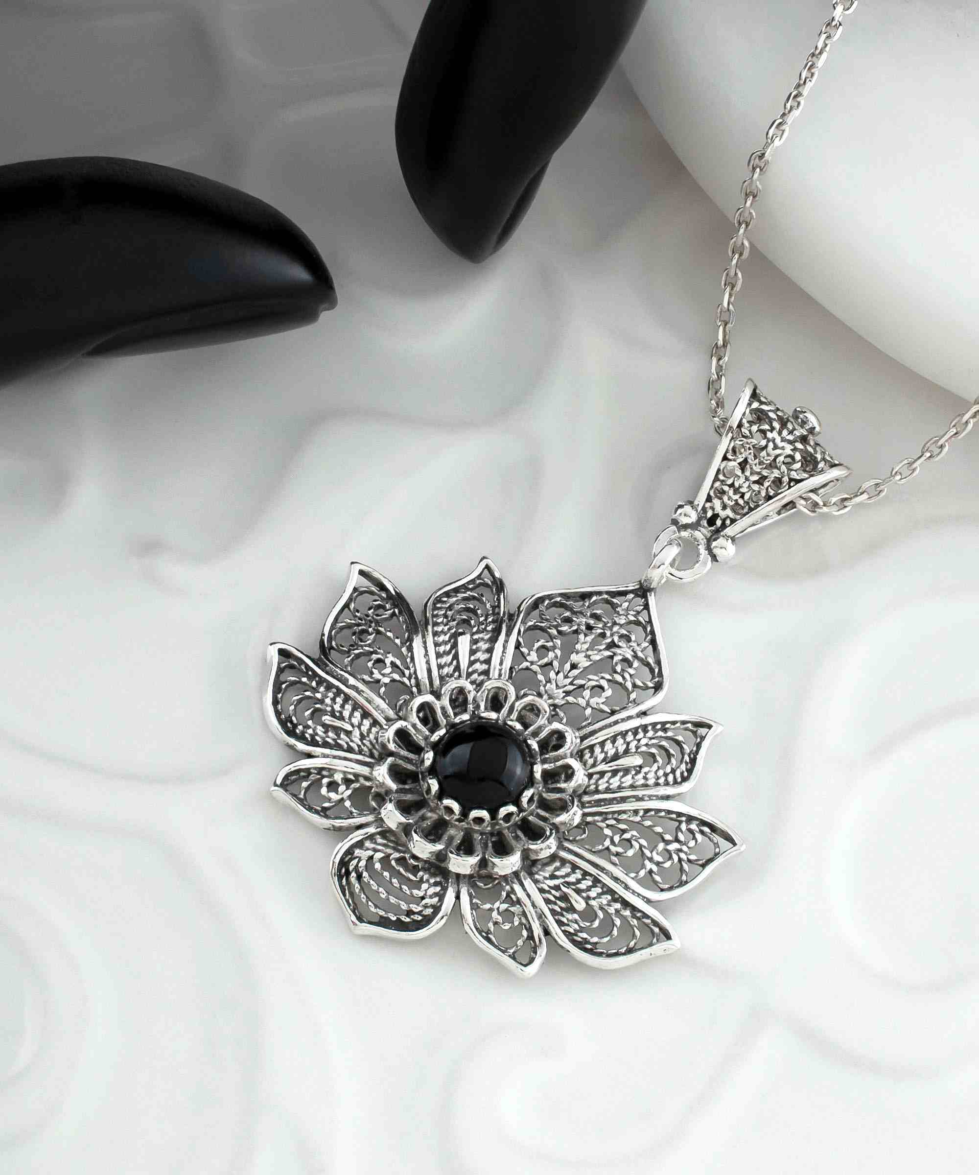 A handcrafted 925 Sterling Silver lotus flower pendant featuring a black onyx gemstone, showcasing intricate filigree art details.