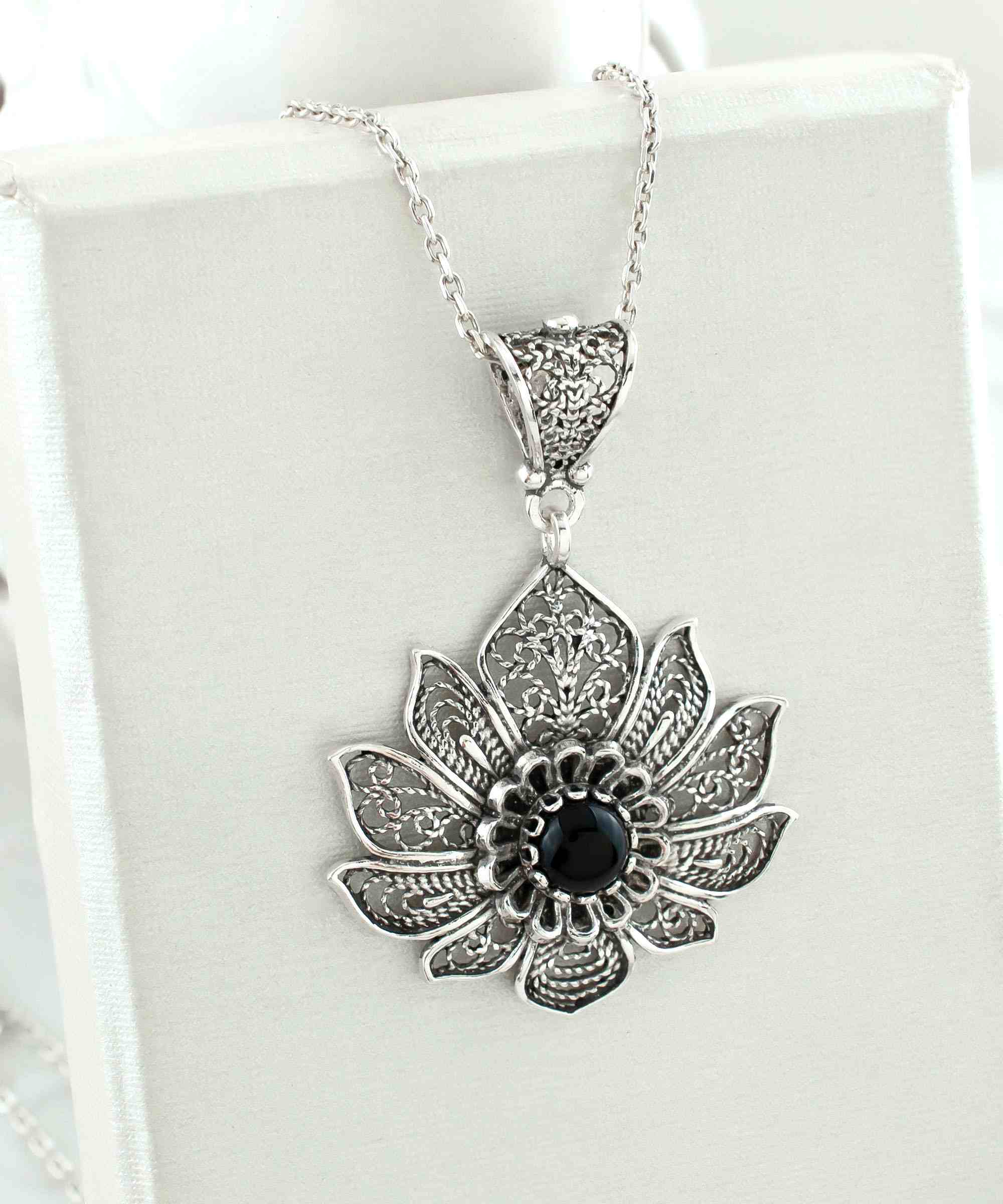 A handcrafted 925 Sterling Silver lotus flower pendant featuring a black onyx gemstone, showcasing intricate filigree art details.