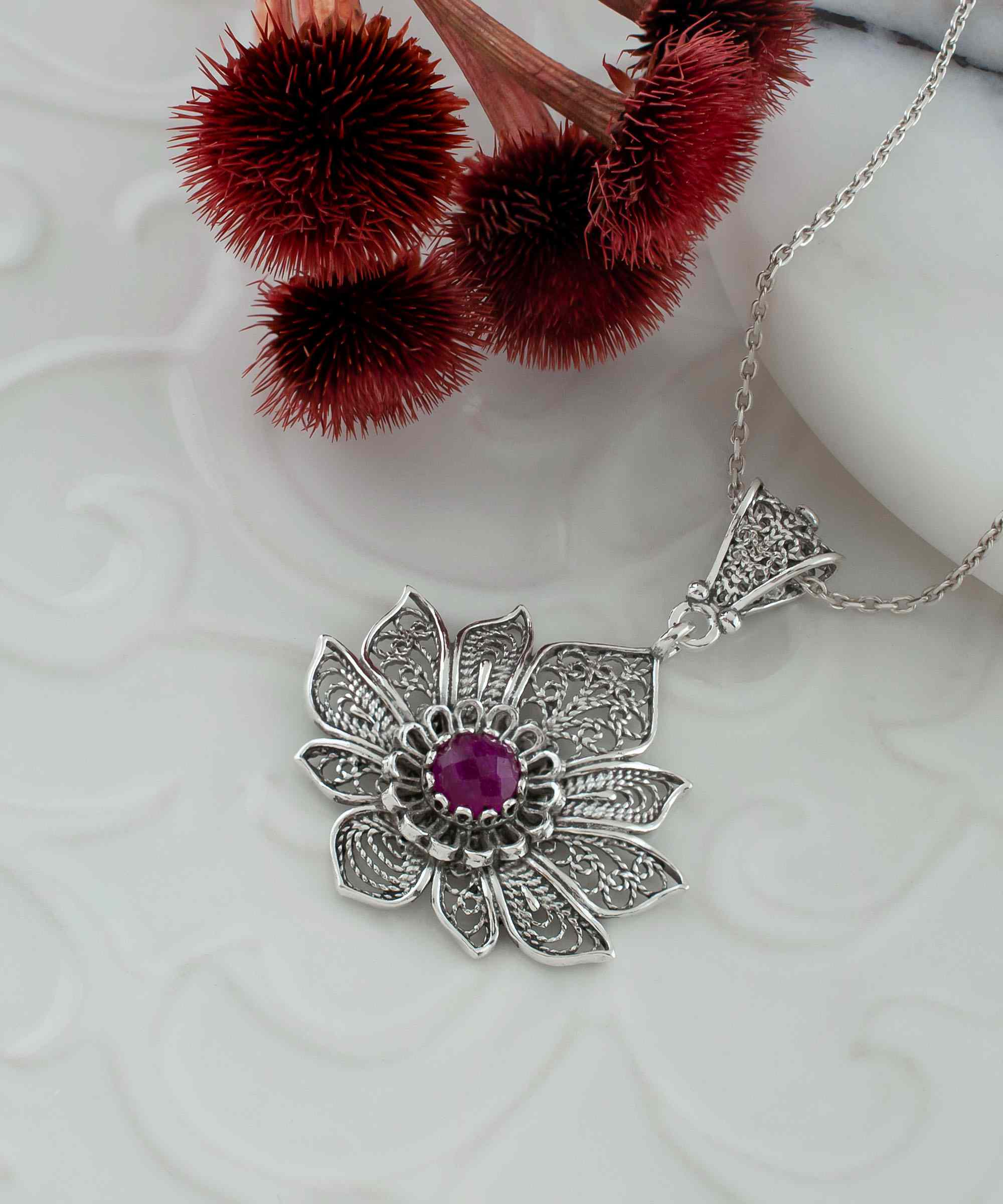 Handcrafted 925 Sterling Silver lotus flower pendant featuring a ruby corundum gemstone, elegantly designed with intricate filigree art.