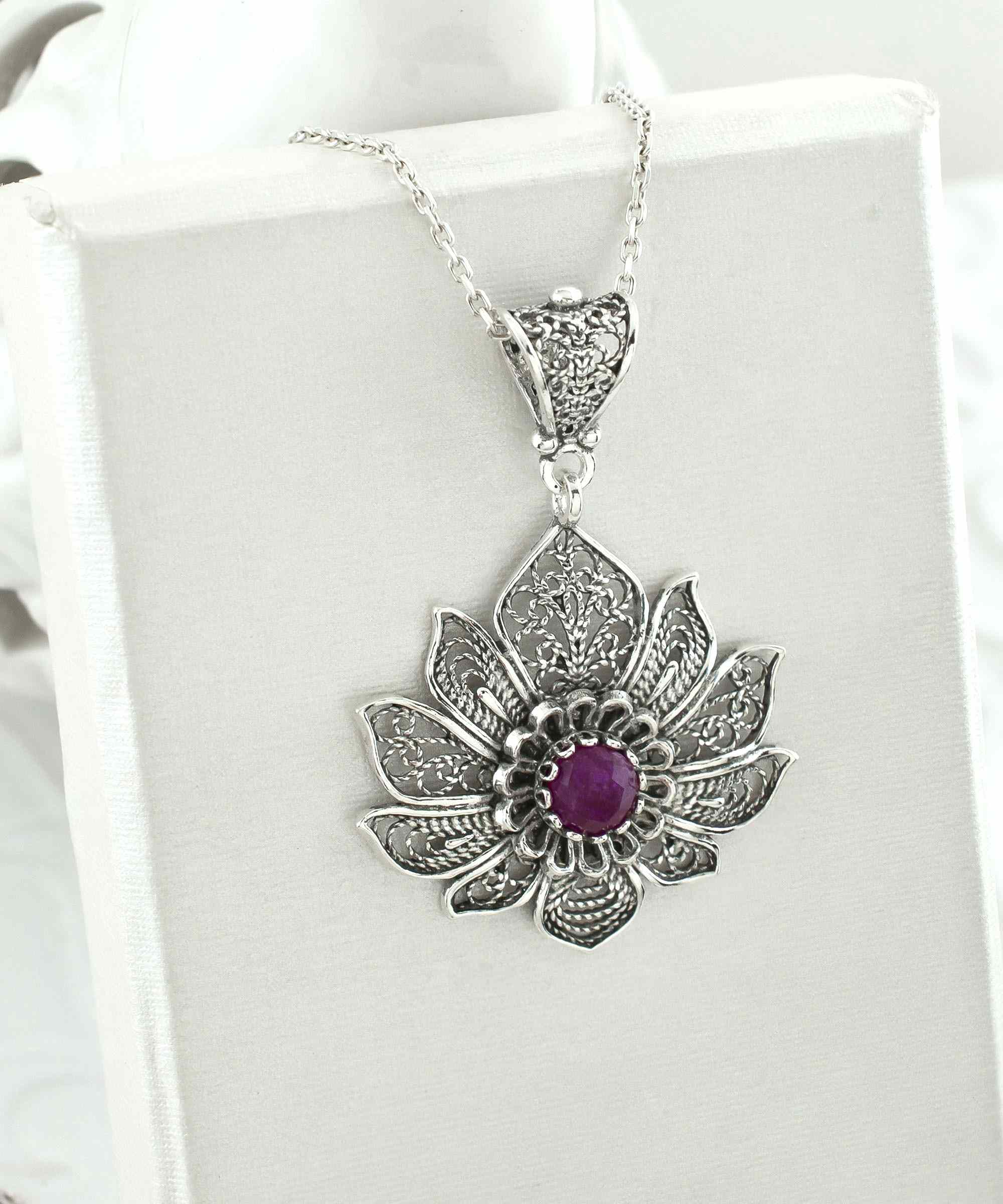 Handcrafted 925 Sterling Silver lotus flower pendant featuring a ruby corundum gemstone, elegantly designed with intricate filigree art.