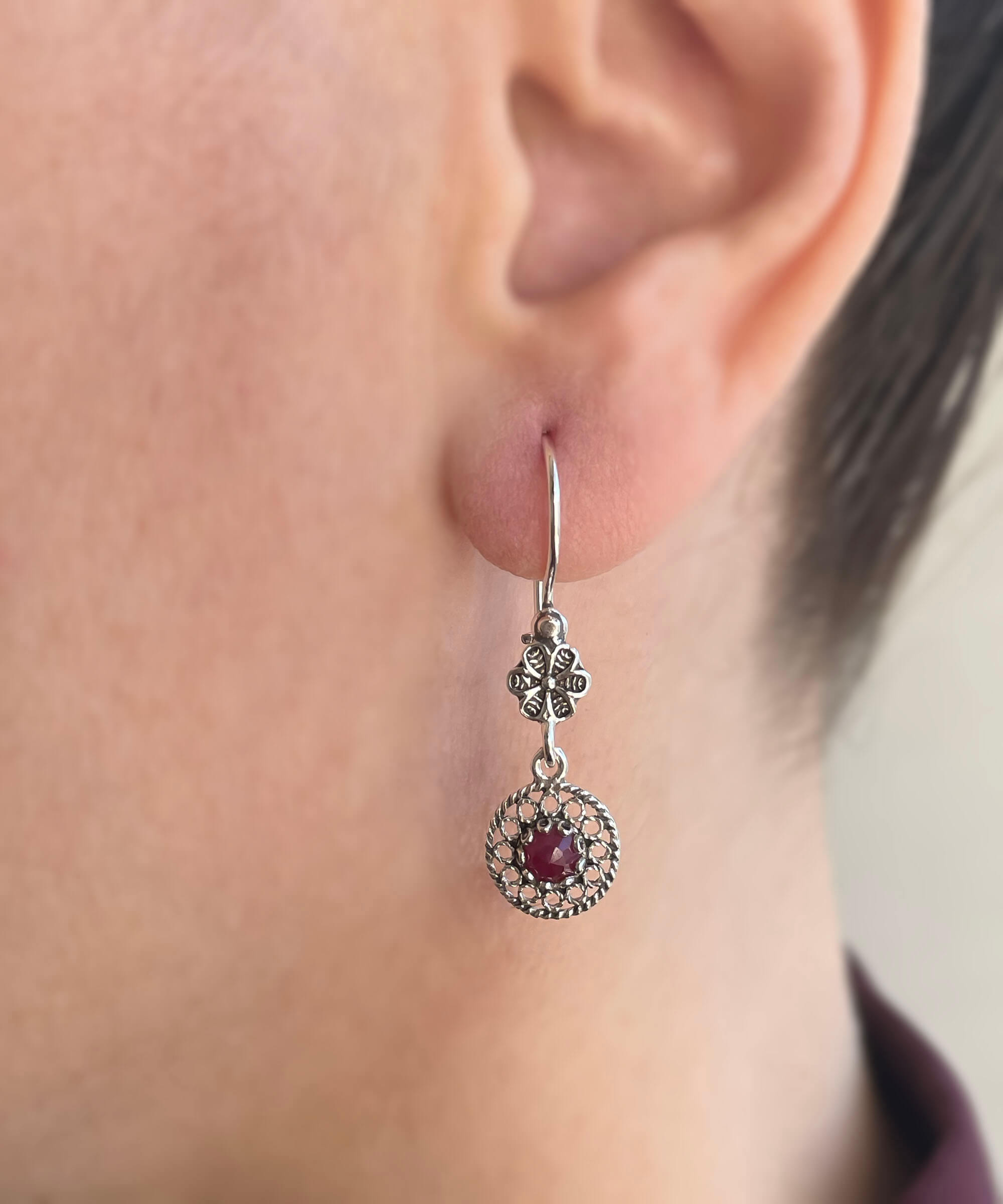 Elegant handmade silver dangle earrings featuring cabochon cut gemstones in various colors, showcasing intricate filigree design.