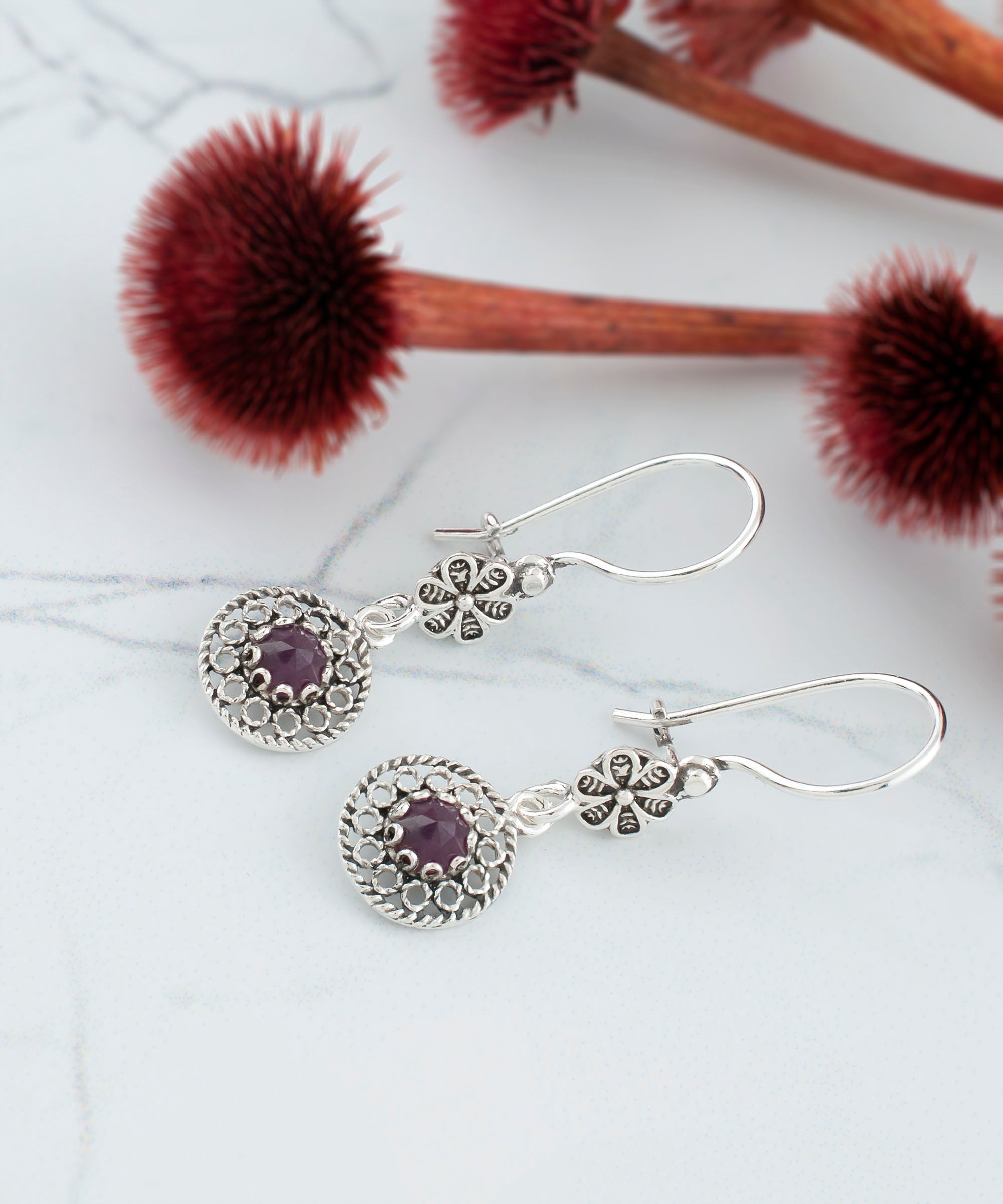 Elegant handmade silver dangle earrings featuring cabochon cut gemstones in various colors, showcasing intricate filigree design.