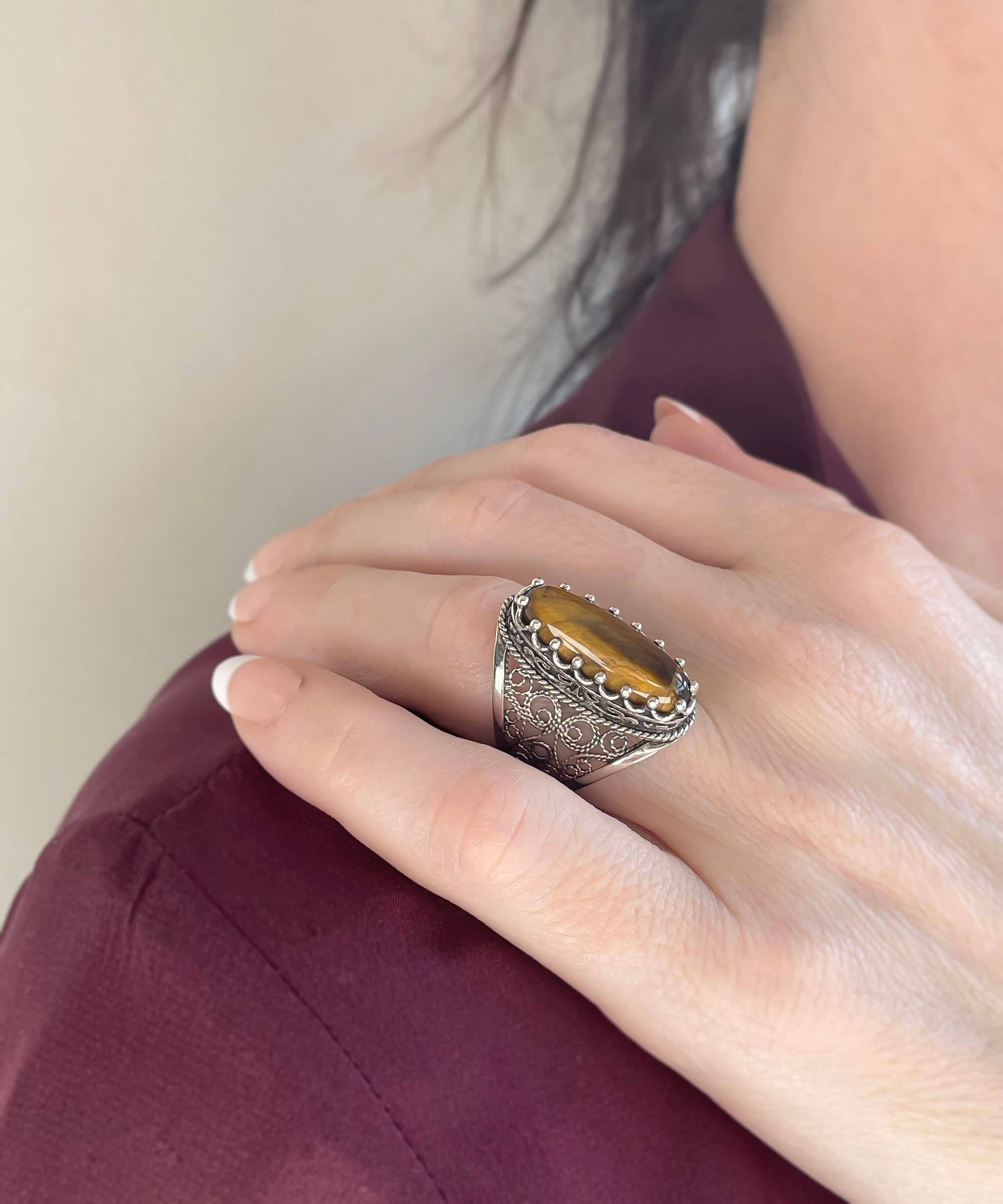 Elegant 925 sterling silver long statement ring featuring intricate filigree design and an oval-cut tiger eye gemstone.