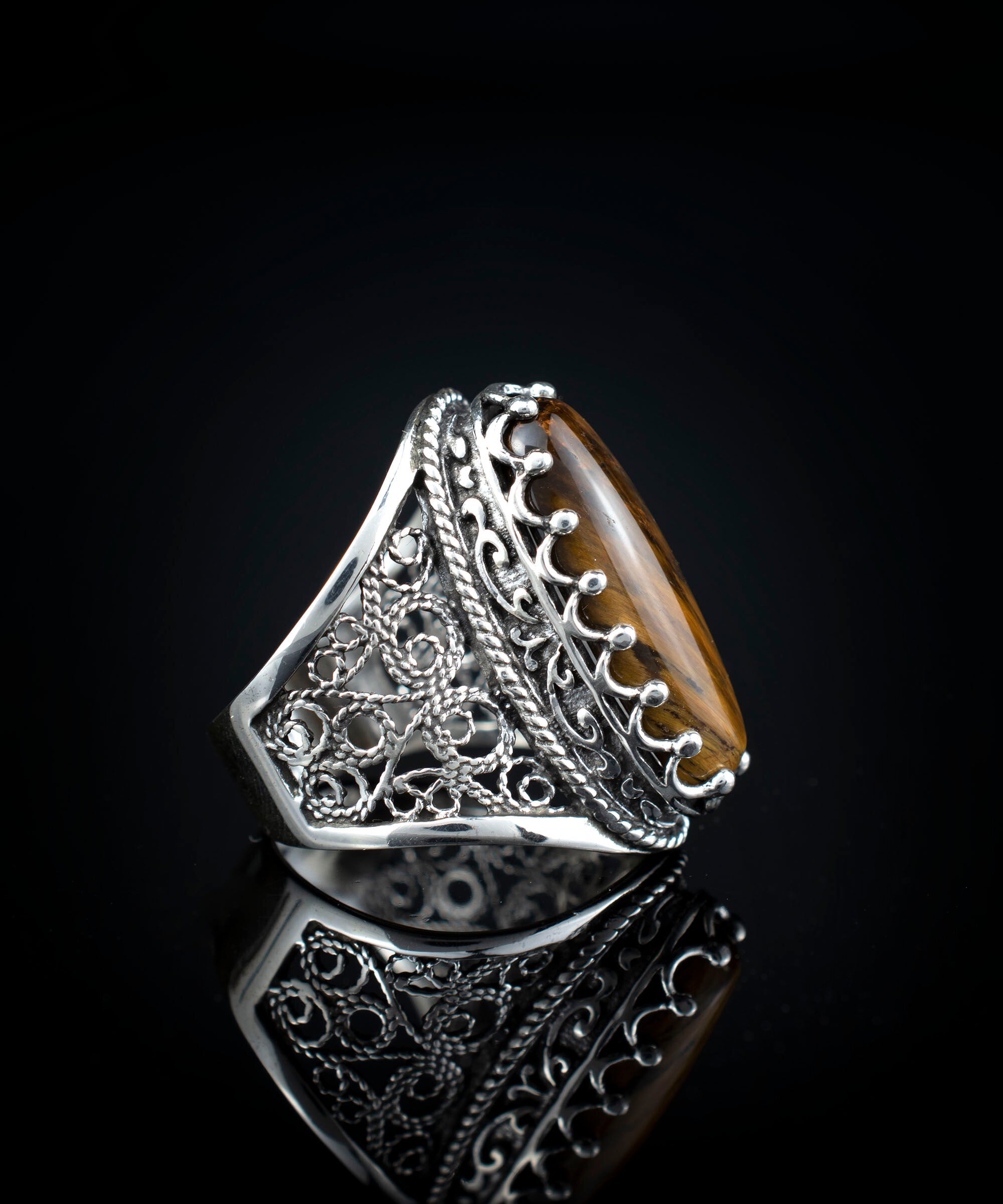 Elegant 925 sterling silver long statement ring featuring intricate filigree design and an oval-cut tiger eye gemstone.