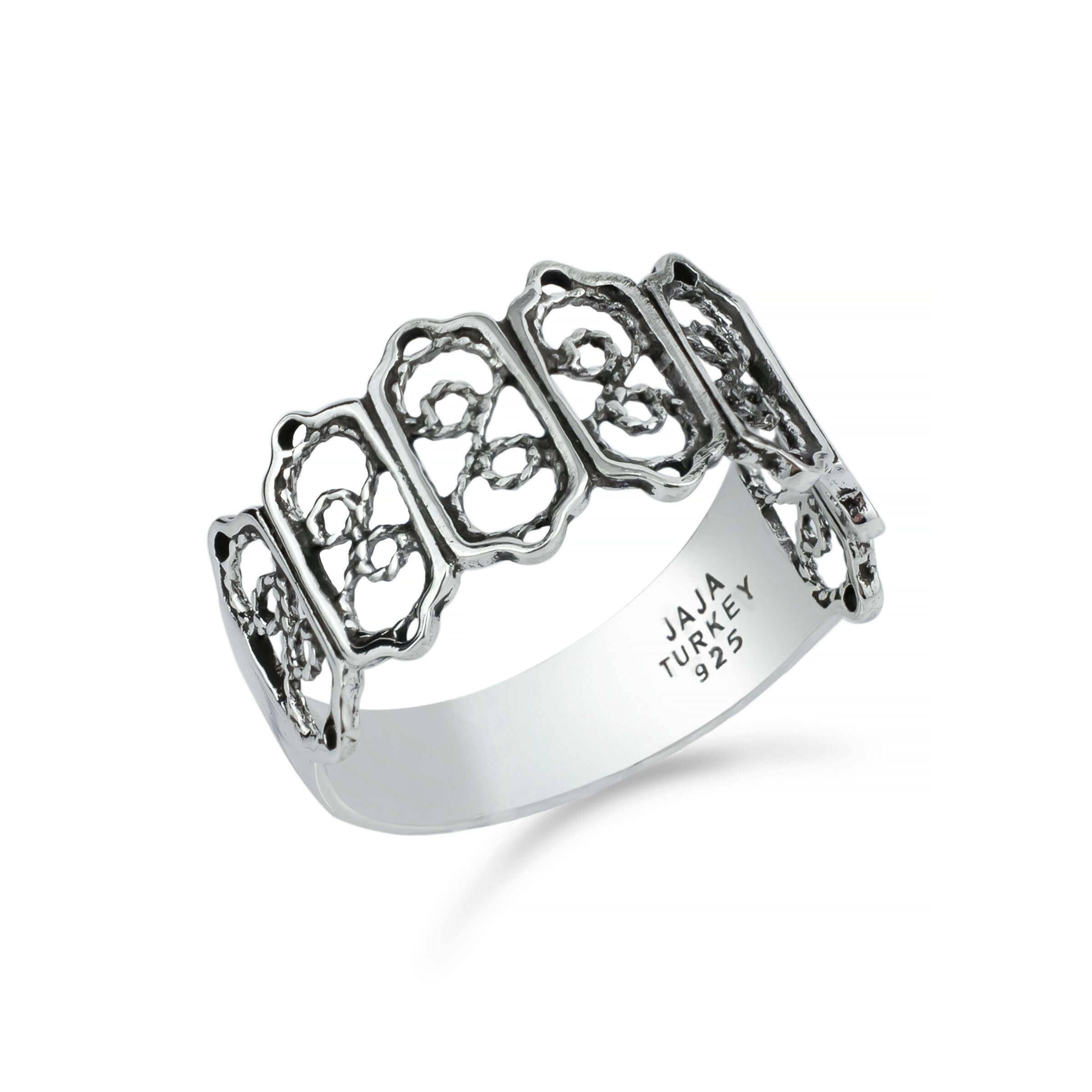 A delicate sterling silver band ring featuring intricate filigree art design, showcasing a polished and oxidized finish.