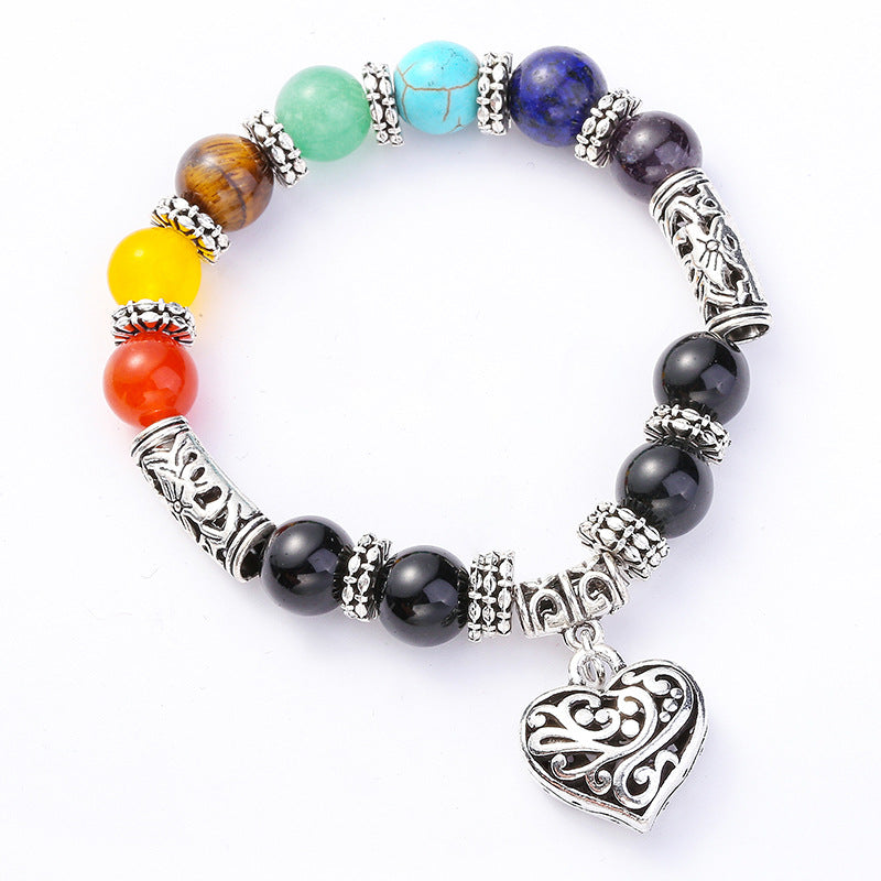 A beautiful silver plated brass bracelet featuring a filigree heart design and vibrant rainbow chakra colors, perfect for women.