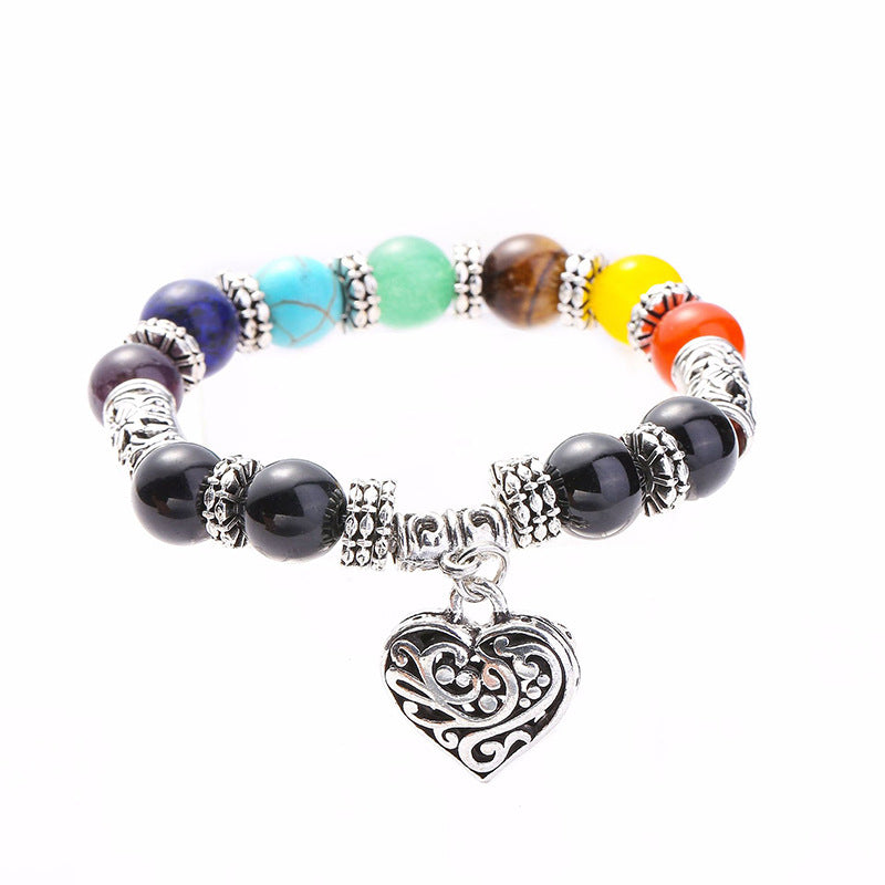 A beautiful silver plated brass bracelet featuring a filigree heart design and vibrant rainbow chakra colors, perfect for women.