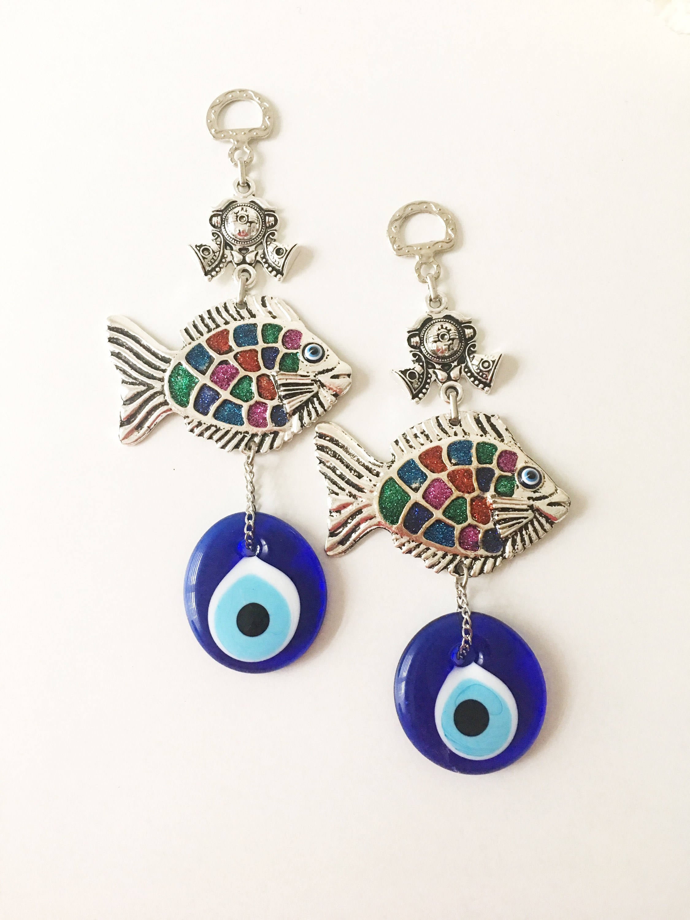 A beautiful Fish Evil Eye wall hanging featuring a fish charm and blue evil eye bead, symbolizing protection and good luck.