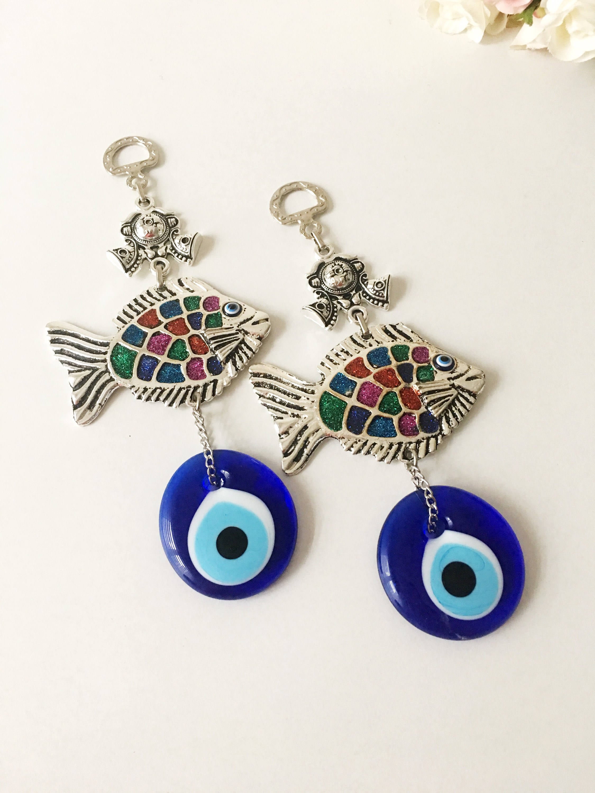 A beautiful Fish Evil Eye wall hanging featuring a fish charm and blue evil eye bead, symbolizing protection and good luck.