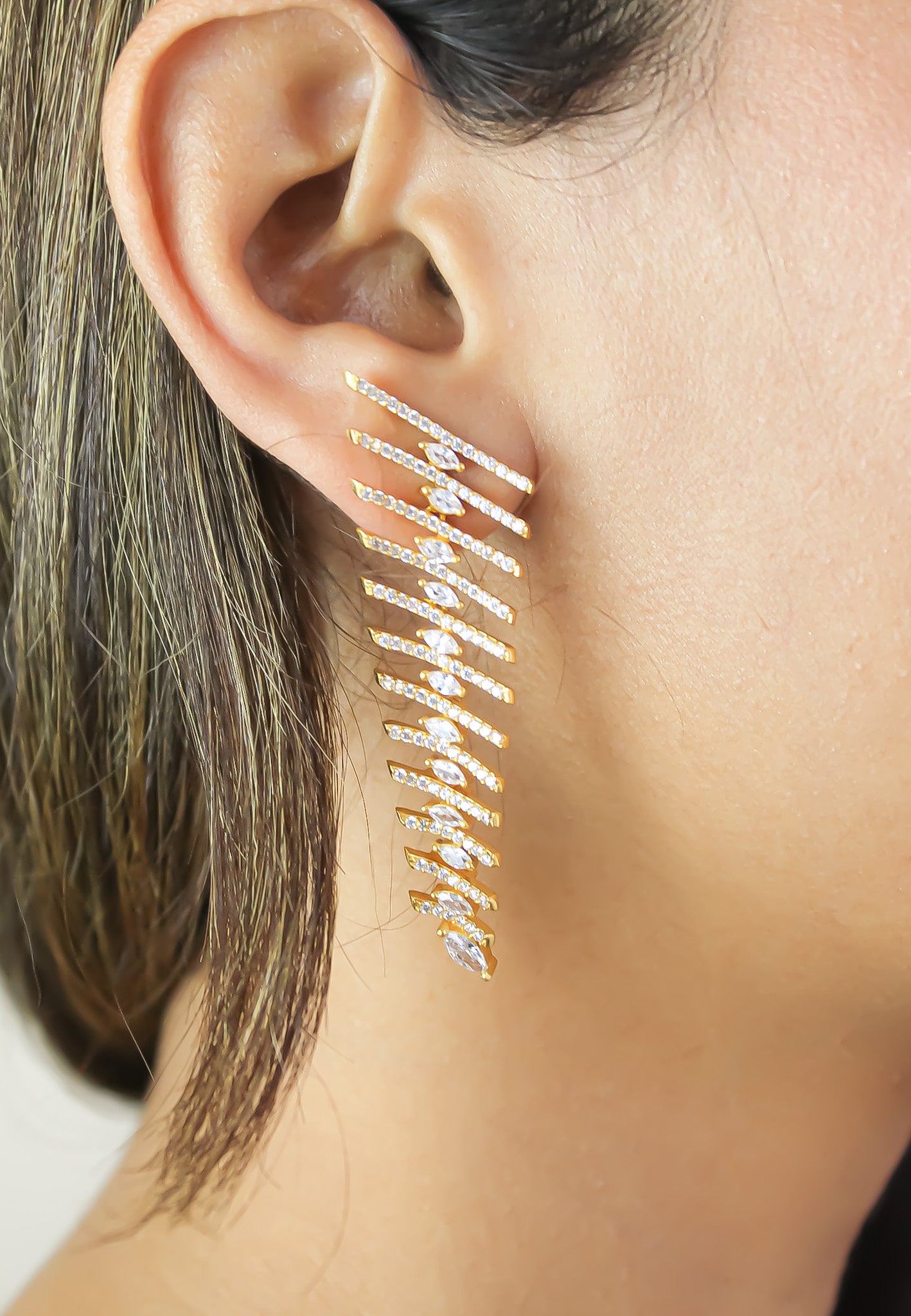 Elegant Fishbone Earrings in gold, silver, and rose-gold plating with zirconia stones, showcasing a modern design.