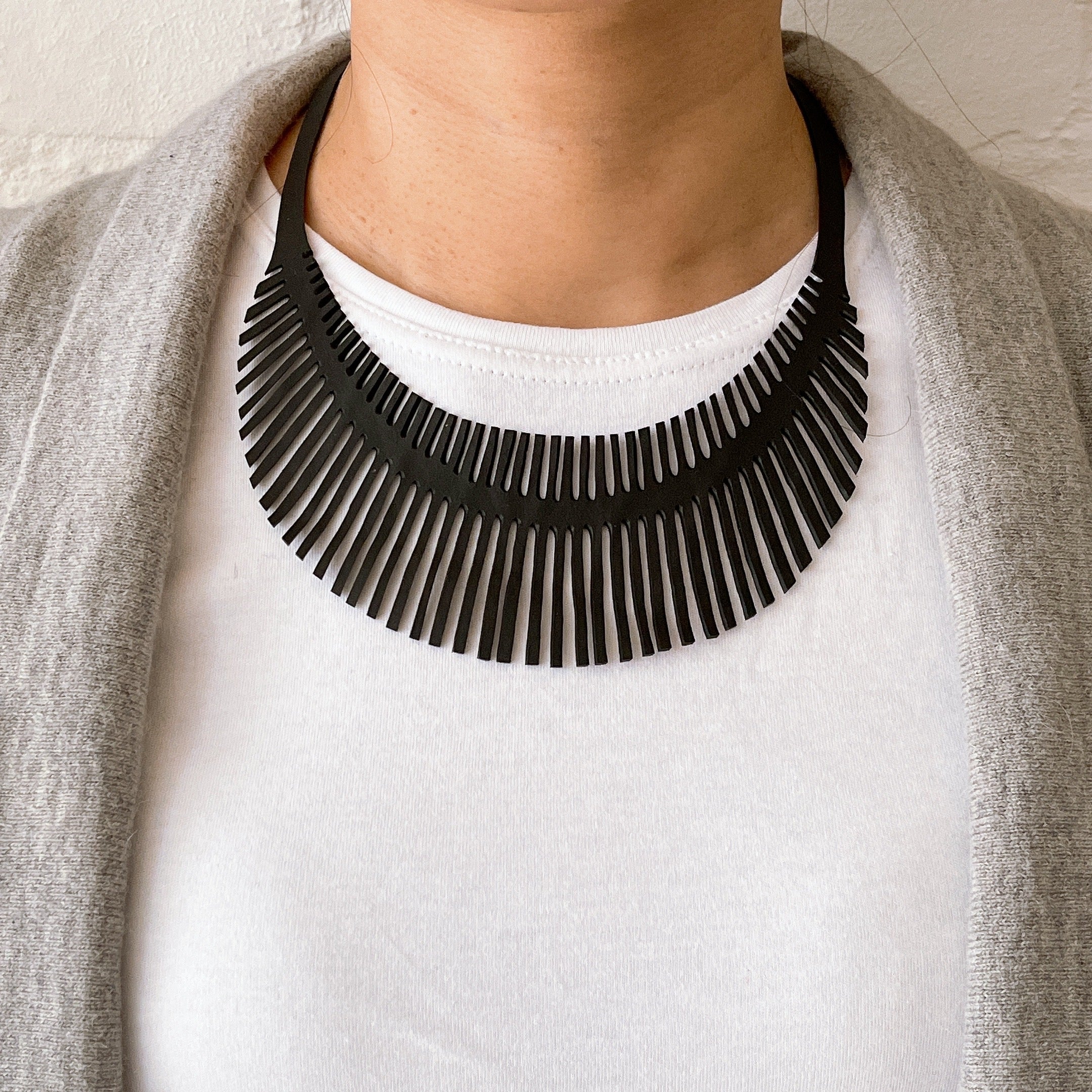 Fishbone Inner Tube Necklace made from reclaimed rubber, featuring a playful design and lightweight construction, ideal for eco-conscious fashion.